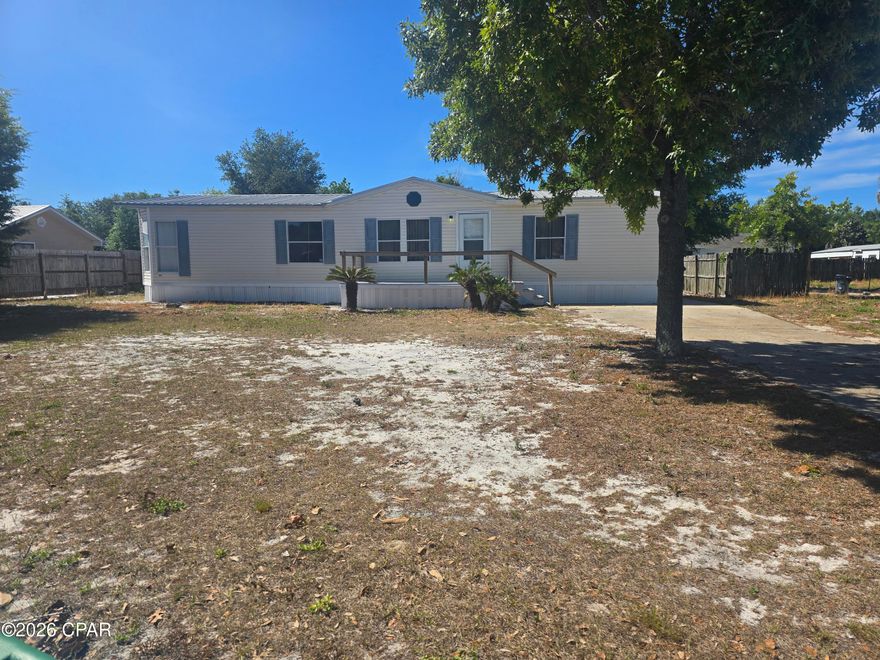 GREAT opportunity to own in a quiet neighborhood which is short term rental friendly just minutes from the white sandy beaches!  This spacious manufactured home has a very roomy open floorplan with lots of large windows for an open and airy feel.  The large  living room features a fireplace that can also be seen from the kitchen.  The breakfast bar is finished with decorative glass door cabinets with a spacious kitchen that allows for a pleasant entertaining space.  ALL 3 bedrooms have walk in closets and the large master bedroom ensuite bath has a large soaking tub.  There is a large 10X10' utility room that is accessable from the laundry room. The 18'x10' covered lanai offers even more entertaining space.  Put this property on your must see list!