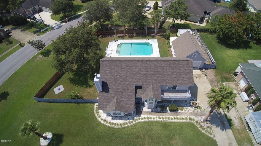 Move in Ready! If you want a large home and a large piece of property in the center of Panama City Beach this home is for you. This traditional 4 bedroom 2.5 bath home with a large laundry/mud room that could be used for an office or an additional bedroom is awesome for a large family. The home comes with an in ground saltwater pool, a detached over sized two car garage and an additional out buildings. The first floor consists of the large living room with laminate wood floors, wood burning fireplace, formal dining room and an eat in kitchen with newer stainless appliances. The upstairs consists of all the bedrooms and an open area at the top of the stairs that could be used as a reading nook. The roof has been replaced and the home has hurricane shutters. Peek a Boo Bay view