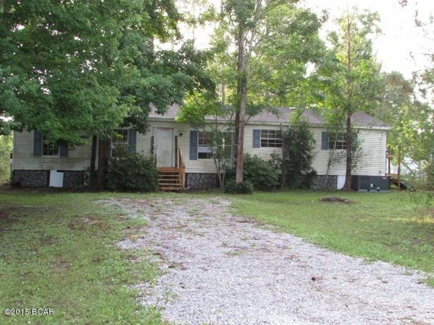 Doublewide sits on a lovely, wooded lot and offers plenty of privacy.  Interior features an ''L'' shaped living/dining area w/corner fireplace, separate kitchen w/breakfast area and utility room, and 4 spacious bedrooms including a master suite w/full bathroom. There's work to be done here for sure but it's a great location for the outdoor lover, so well worth the work. Wow, this home is a block away from Deer Point Lake, so bring the boat! EQUAL HOUSING OPPORTUNITY.