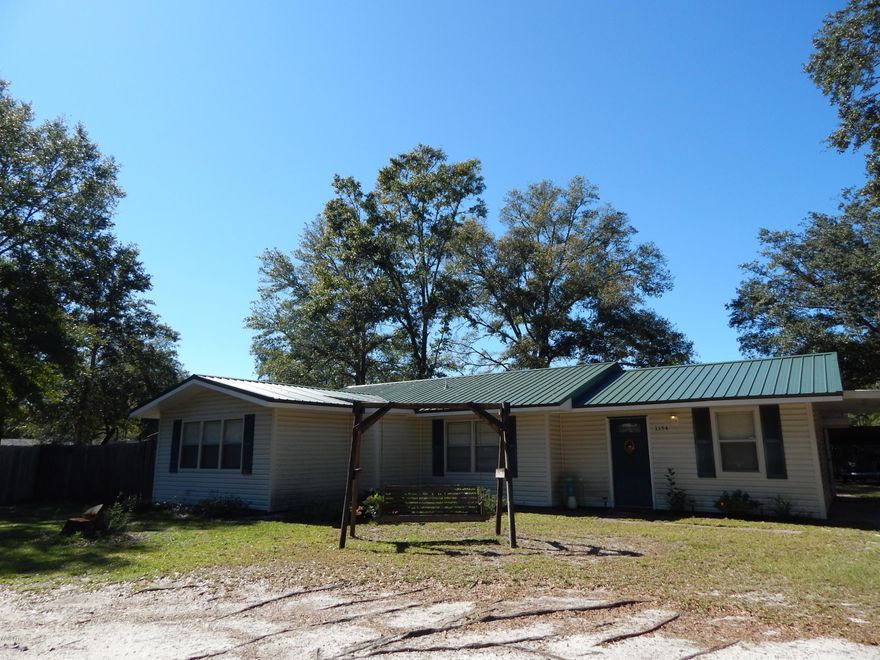 100% financing is possible on this adorable and affordable home on a half acre lot in Southport!  Lots of upgrades....new metal roof, new kitchen counters and backsplash, new flooring in living area, newer water heater and air compressor, plus an added a patio. Kitchen is open to the living area  The master bedroom has the attached bathroom and a large walk in closet.   Home is on a termite bond for added protection.   A large carport/polebarn for cover for boats, campers, and cars. The location is great....you are removed from the hubbub of town and still close enough to be convenient to PC and more. Make your appointment to see this today!!