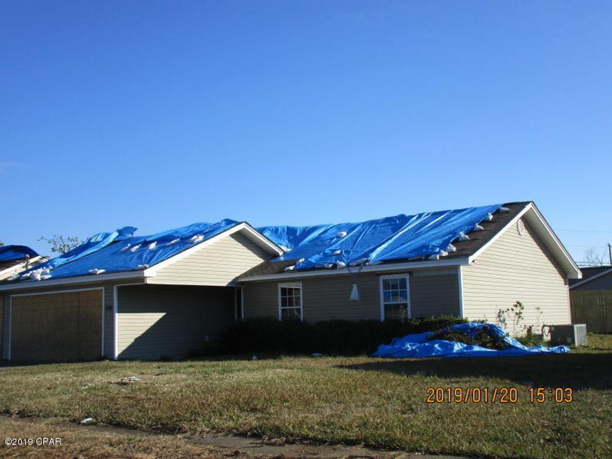 This house was damaged in Michael. It has tarped roof, bad sheet rock was torn out by insurance company contractors /the damaged ceilings have also been torn out and has plastic on ceilings. It has had damaged sheet rock and carpet removed from house. Garage needs extra tlc as one wall moved out about 2 feet more or less.and garage door was damaged. It is in repairable condition and ready to be worked on, The back neighbor has just installed a new back fence the fence all around the house blew down.