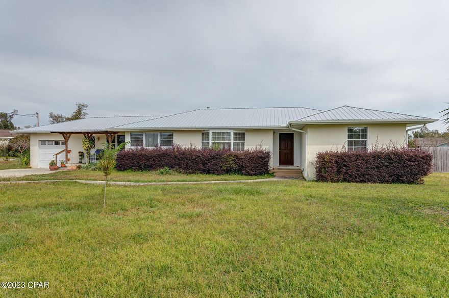 Explore this Lynn Haven home, quietly nestled on a spacious half-acre corner lot. Conveniently located just two blocks from the bay and Kinsaul Park, this 3 bedroom, 2 bath house features a living room with an electric fireplace, a dining area, and a generous family room. All bedrooms are equipped with built-in closets, and the entire house showcases original wood floors.
This residence offers practical amenities such as a large deck for family BBQs with a fenced backyard, providing a safe space for kids and pets to play freely. Additionally, a 24x30 workshop with garage doors offers ample storage and versatility. The property includes a one-car attached garage and a covered front porch off the family room. Roof was replaced recently, in 2019, A/C updated in 2017, electric water heater in 2015. The entire lot is in Zone X, so flood insurance is optional and not required!
Don't miss out on this rare find in town! Schedule your appointment today to explore the unique features and potential of this well-located Lynn Haven property. Age, square footage, and room sizes are approximate; for essential details, please verify independently.