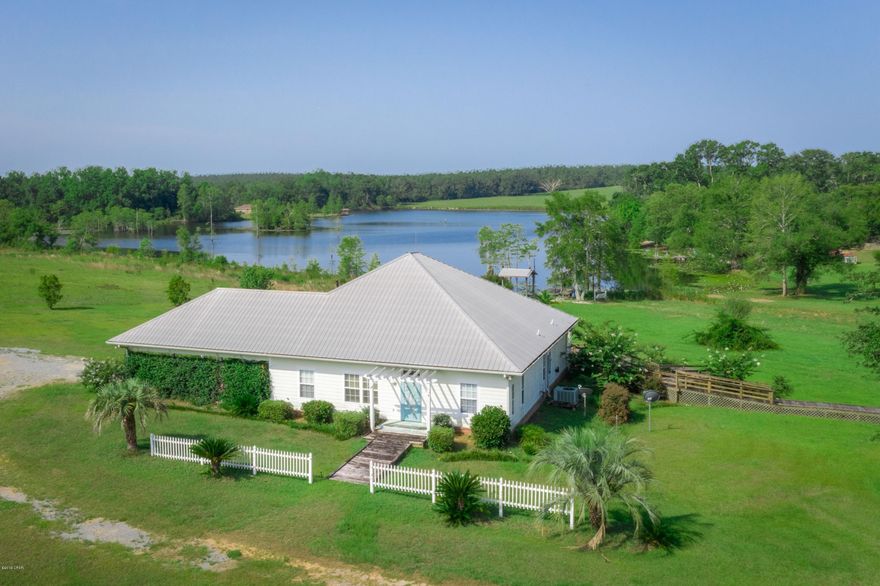 CURRENTLY UNDER CONTRACT, SELLER ACCEPTING BACKUP OFFERS. Enjoy the lake view with this Russ Lake beauty! Beautiful 4/2.5 home offers a kitchen with lots of storage, Florinada countertops, pass through to the dining room, breakfast bar and is open to the living room with a cathedral ceiling and a gas fireplace. Formal dining room. Master bedroom with his/her closets, separate vanities, jacuzzi tub, tiled shower with access to carport. There are french doors in the master, living room and 4th bedroom to access the back deck area, great for entertaining or relaxing after a day on the lake. Bedrooms 2 and 3 share a Jack N Jill bathroom. Bedroom 4 has spruce log cabin walls, cypress beaded ceiling and a half bath. Large laundry room. Home is handicap accessible. Outside you will find a worksh to the lake. You have your own private fishing dock with electricity. Electric motors only allowed on lake. Sits on 4.14 acres, nicely landscaped. Come enjoy your own piece of paradise!