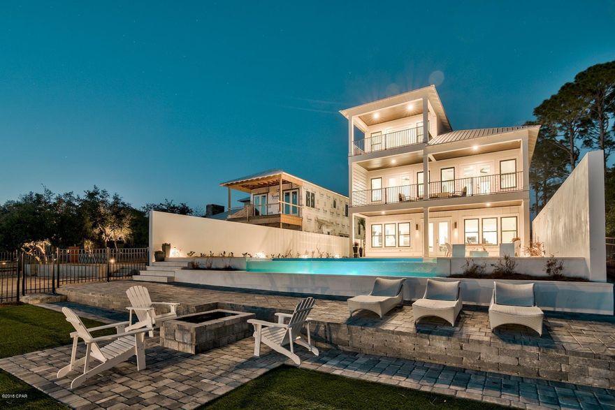 Framed by brilliant sunsets and pristine water vistas, this newly constructed five bedroom coastal retreat boasts unrivaled luxury combined with a central location offering rare deep water harborage & boating access complimented by a 40' covered boat slip. This 4,175 square foot residence, completed in the Summer of 2017, has an open floor plan that maximizes water views from each level including the dual second-floor master bedrooms. The entertainment space in the home is unparalleled, having two living rooms, both with water views, and a sublime third floor bonus room that could also be converted into a waterfront office space or additional sleeping area. The ample sized pool deck further enhances the atmosphere of luxury coastal living with its outdoor kitchen and infinity edge pool that overlooks the water. Both the gulf and the bay are only a short boat ride away, providing families the best of both worlds that waterfront living has to offer. The open floor plan on the first level creates an inviting and spacious atmosphere characterized by the extraordinary chef's kitchen complete with granite countertops, sleek granite backsplash, wine cooler, wet bar with floating shelves and stainless appliances. The kitchen seamlessly connects to the oversized entertainment and family room all of which is south facing focusing on endless views of the water. The second floor master suite is the epitome of luxury and comfort. Thoughtfully designed and beautifully decorated, this incredible space has modern finishes complete with a king size bed that overlooks the water and a balcony that offers breathtaking sunset vistas. The master also features a spa-like ensuite bathroom complete with a large soaking tub, dual vanities and a walk-in shower. The second floor of the home boasts an incredible outdoor entertainment space with an oversized waterfront balcony that spans the entire length of the house with access from the master suite and the second floor living area which also offers a wet bar and wine cooler. The third story is a bonus room that can be utilized for a multitude of function offering outstanding view corridors.There's also another 18.8'x20.0' master bedroom above the garage complete with an ensuite bath and water views. This could be converted into a bunk room, children's play room, game room, office space, in-law suite, or storage area. The garage can comfortably fit two cars and there is ample additional parking in the driveway. The estate sized lot offers professionally designed and manicured grounds beautifully curated by Bay Landscaping. 8109 N Lagoon is the pinnacle of waterfront living in Panama City Beach offering the best of both worlds with access to all of the commercial amenities that Bay County has to offer including world class restaurants, shopping, golf courses and local entertainment.