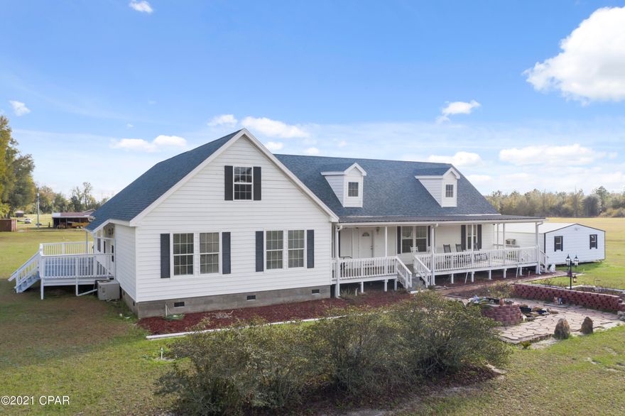 Breathtaking, custom-built, country style home thoughtfully constructed on over 12 acres of peace and tranquility. Boasting over 5,000 sq ft of elegant living space this 3 bedroom, 3 bath luxury estate features custom tiled flooring, spacious living room with an abundance of natural lighting, formal dining room and  a gourmet kitchen with custom built cabinetry, granite countertops, stainless steel appliances, and island with breakfast bar. Enter through your own personal library to the master suite that spares no expense with double sinks, granite counters, jetted soaking tub, walk-in shower and an oversized closet that conveniently leads to the laundry room. On the opposite side of the home you will find 2 additional massive bedrooms and 2 full baths that complete the main level. And if that isn't enough space for you continue up the spiral staircase to the completely finished bonus room measuring approximately 1,800 sq ft! Enjoy your days outside sitting on the front porch in the rocking chair admiring the 38 varieties of roses, entertaining guest on the expansive back porch or watching your horses on the 7.2 acre already partially fenced. Property is located approximately 10 minutes from Marianna and a short drive to Hwy 231.