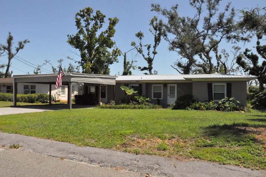 Charming 3/1 cottage in the Cove with many updates!  Beautiful granite in the kitchen, large dining area, and original hardwood floors throughout the living room and all three bedrooms.  Updated bath with shower/tub combo.  Very sturdy, two-car carport and a metal roof. You will fall in love with this sweet Cove home!  All measurements, sizes and dimesions approximate.  Buyer to verify if important.