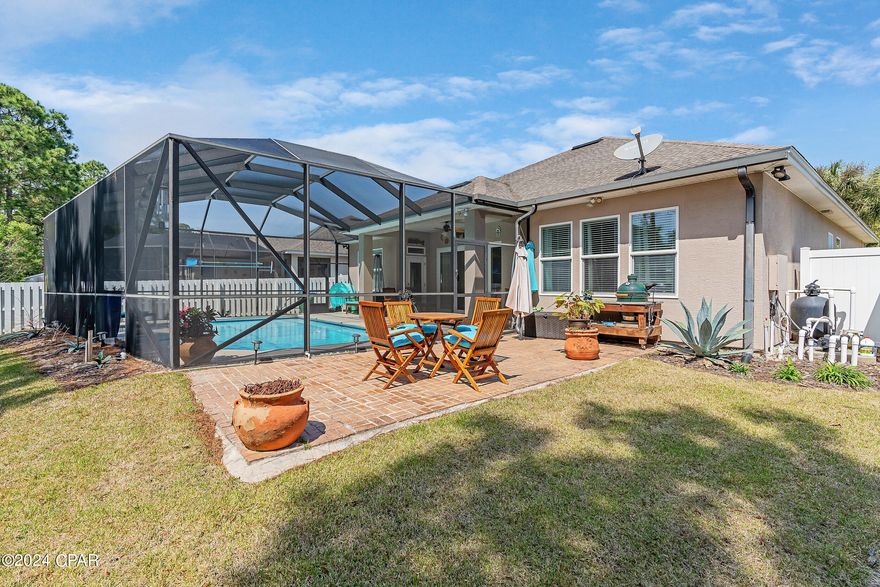 CURRENTLY UNDER CONTRACT, SELLER WILL CONSIDER BACKUP OFFERS *PRIVATE POOL & BACKYARD* This impeccably maintained 3BR/2BA home, with an additional BONUS ROOM WHICH COULD BE A FOURTH BEDROOM, is nestled in the popular Palmetto Trace neighborhood. Backing up to a peaceful wooded area with no neighbors behind, it offers a private backyard oasis that includes a screened-in pool. Inside, the elegant home features practical tile throughout the foyer, bathrooms, kitchen and other common areas, while the bedrooms and additional room boast hardwood floors. The heart of the home is a sprawling living, dining and kitchen area with lofty 10-ft ceilings, ideal for both living and entertaining. The kitchen is outfitted with stainless appliances, cherry cabinets, recessed lighting, tile backsplash and granite countertops. A functional butler's pantry and cozy breakfast nook sit adjacent to the kitchen for added convenience. An adjoining formal dining area seamlessly transitions into the living room. The generously sized master bedroom leads to a roomy ensuite bath complete with a walk-in shower, double vanity with custom cabinets, a large garden tub, and a spacious master closet. All toilets have been upgraded to chair height. The house has hurricane impact windows for added peace of mind and protection during inclement weather. The owners repainted the exterior just two years ago and replaced the Polaris pool pump and chlorine generator last year. A HVAC UV light has also been installed to improve the quality of the indoor air by killing viruses and bacteria, eliminating mold and mildew, and reducing odors. Palmetto Trace is a beautifully landscaped, golf-cart friendly community with sidewalks and two community pools. Centrally located, it offers easy access to Pier Park, Frank Brown Park, Aaron Bessant Park and Gayle's Trails, all just a short golf cart ride or walk away. Additionally, the new hospital site and airport is just minutes away. Don't miss the opportunity to make this serene retreat your home sweet home. Schedule a viewing today!