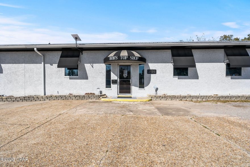 388' OF PRIME HWY 98 FRONTAGE • 1.26 ACRE CORNER LOT • FLEXIBLE MIXED-USE ZONING - Position your business on one of Panama City's most visible commercial corridors! Located directly on Business Hwy 98 (E 5th Street) with an AADT of 19,300 vehicles, this 1.26-acre corner property offers an impressive 388' feet of prime highway frontage, providing exceptional visibility, accessibility, and marketing exposure. The fully fenced in property allows two convenient access points for ingress and egress, making the property ideal for customer access, deliveries, and operational logistics. 

Zoned as Neighborhood Downtown (ND), this flexible mixed-use zoning designation allows for a broad range of potential commercial, residential, and mixed-use development opportunities (more information in document section).

The property features roughly 6,200 square feet of total building space, including the main operational building with a reception area, two offices, three bathrooms, and a spacious 52'5'' x 32' open sewing and multi-purpose workspace. The building also includes a 43' x 44' receiving and logistics area, currently unfinished but fully equipped with its own HVAC system and two roll-up doors, offering flexible space for storage, production, or distribution operations. In addition, the property includes a separate 1,500-square-foot heated and cooled welding workshop, also equipped with roll-up doors, providing a functional workspace suitable for fabrication and mechanical uses. *Newer HVACs on site and a 2019 metal roof. 

Located within the Millville Downtown District and just minutes from the revitalized  Downtown Panama City waterfront, the property lies within a Community Redevelopment Agency district (CRA), providing potiental incentives and grant programs  that may support property improvements or redevelopment. 

The established business currently operating on the property, is also available for purchase in conjunction with the property; however, the business valuation is separate from the advertised real estate price. Bob's Top Shop is a well-established custom awning and canvas fabrication business with deep roots in Panama City, known for producing high-quality commercial and residential awnings, marine canvas, and specialty products throughout NW Florida. With decades of brand recognition, repeat clientele, and strong community relationships, this presents a rare opportunity for an owner-operator, contractor, or investor seeking a respected local brand with continued growth potential.  

Whether you're interested in acquiring the property as a ready-to-go operation or exploring the many development possibilities for your own business, this highly visible and strategically positioned site offers endless opportunities. Don't wait, schedule your showing today!

Parcels 22284-000-000 & 22704-000-000 being sold together. Buyer to verify all measurements.