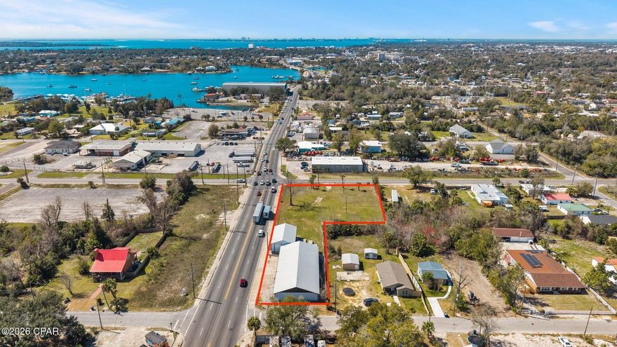 388' OF PRIME HWY 98 FRONTAGE • 1.26 ACRE CORNER LOT • FLEXIBLE MIXED-USE ZONING - Position your business on one of Panama City's most visible commercial corridors! Located directly on Business Hwy 98 (E 5th Street) with an AADT of 19,300 vehicles, this 1.26-acre corner property offers an impressive 388' feet of prime highway frontage, providing exceptional visibility, accessibility, and marketing exposure. The fully fenced in property allows two convenient access points for ingress and egress, making the property ideal for customer access, deliveries, and operational logistics. 

Zoned as Neighborhood Downtown (ND), this flexible mixed-use zoning designation allows for a broad range of potential commercial, residential, and mixed-use development opportunities (more information in document section).

The property features roughly 6,200 square feet of total building space, including the main operational building with a reception area, two offices, three bathrooms, and a spacious 52'5'' x 32' open sewing and multi-purpose workspace. The building also includes a 43' x 44' receiving and logistics area, currently unfinished but fully equipped with its own HVAC system and two roll-up doors, offering flexible space for storage, production, or distribution operations. In addition, the property includes a separate 1,500-square-foot heated and cooled welding workshop, also equipped with roll-up doors, providing a functional workspace suitable for fabrication and mechanical uses. *Newer HVACs on site and a 2019 metal roof. 

Located within the Millville Downtown District and just minutes from the revitalized  Downtown Panama City waterfront, the property lies within a Community Redevelopment Agency district (CRA), providing potiental incentives and grant programs  that may support property improvements or redevelopment. 

The established business currently operating on the property, is also available for purchase in conjunction with the property; however, the business valuation is separate from the advertised real estate price. Bob's Top Shop is a well-established custom awning and canvas fabrication business with deep roots in Panama City, known for producing high-quality commercial and residential awnings, marine canvas, and specialty products throughout NW Florida. With decades of brand recognition, repeat clientele, and strong community relationships, this presents a rare opportunity for an owner-operator, contractor, or investor seeking a respected local brand with continued growth potential.  

Whether you're interested in acquiring the property as a ready-to-go operation or exploring the many development possibilities for your own business, this highly visible and strategically positioned site offers endless opportunities. Don't wait, schedule your showing today!

Parcels 22284-000-000 & 22704-000-000 being sold together. Buyer to verify all measurements.