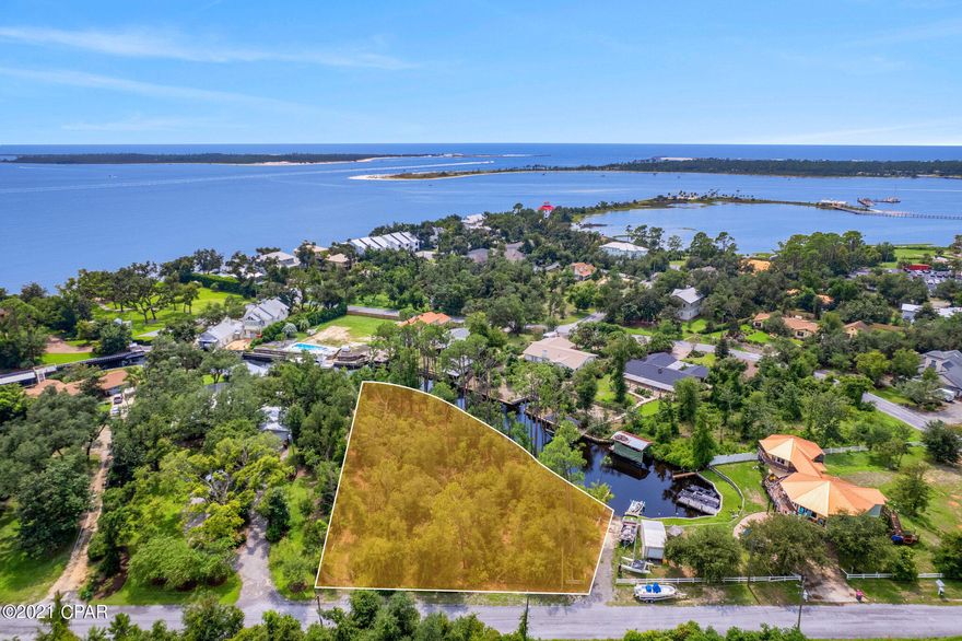 Under contract - seller will consider backup offers. This amazing property is now available, offering approx. 350 canal-front feet with deep water access to St. Andrews Bay. The possibilities are limited only by your imagination.  This private property is tucked away in a quiet neighborhood with no HOA and the short ride out of the canal leads you to St. Andrews Bay...... just minutes from the Pass out to the Gulf of Mexico and all the enjoyment the open water brings with no bridges to navigate.  Suitable for an extremely private estate with almost an acre  of property or develop the property for multiple residences based on zoning and lot dimensions. Bring all your water toys and make this special property yours today. Drawings are artist's renderings, not approved building plans.