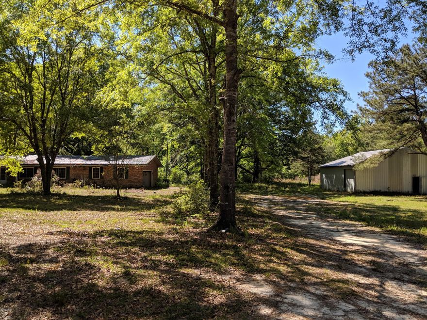 Incredible fixer-upper deal on 20 Acres. This 3 Bedroom 2 Bath home nestled on 20 acres, features a large metal workshop with multiple roll up doors, a small creek branch, a large pond, and loads of hardwoods. The property is located on a paved road, and is approximately 1 hour from the Worlds Most Beautiful Beaches. Schedule your showing today!