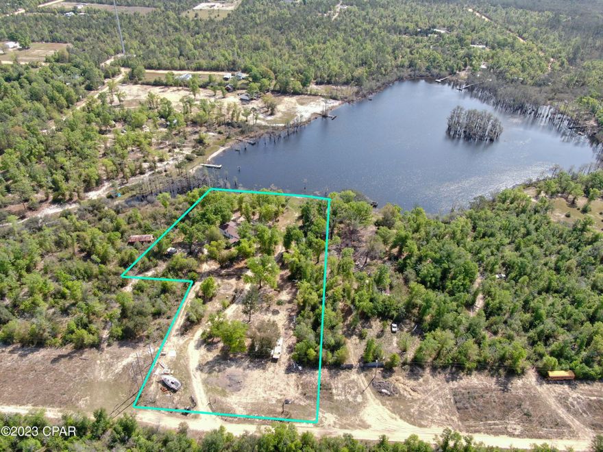 Peace and tranquility! This 3 acre property sits on a spring fed lake.  Spend the days bass fishing, swimming, or just paddling your kayak around this beautiful lake.  Want room for the family?  There are 3 separate addresses with this property.  Each has a septic system and power pole. There are two wells that need repairing.  A little bit of TLC and this place will be paradise! Located 45 minutes from Panama City, shopping, dining, and the beaches of Panama City Beach. All measurements are approximate, verify if important.