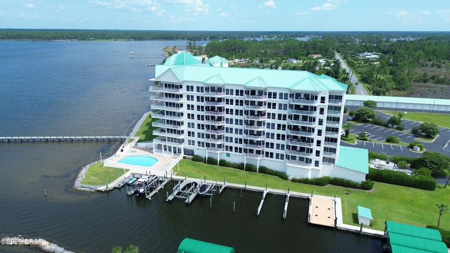 Immaculate Marina Bay Condo with a Garage on North Bay, just over Bailey Bridge in Lynn Haven.  Wonderful water and sunset views from most every room of this two bedroom, two bath home. Large balcony allows for breathtaking panoramic views of North Bay and beyond.
This home has been thoughtfully cared for and very well maintained. You'll appreciate the Brazilian cherry wood flooring and the exquisite crown molding throughout. Newer appliances and fresh interior and exterior paint, along with newly epoxied walkways and balconies. Home comes fully furnished (other than owner's personal items). The grand open foyer leads to a spacious living area and waterfront master suite, along adjoining guest bedroom and large laundry room. Open kitchen overlooks living and dining area, while offering striking water views. Marina Bay offers a quiet residential setting with all the desired amenities you're sure to enjoy, from the large pool area, hot tub, community room, gym, fishing/docking pier, marina and covered parking. This home comes with Garage #20 for all your work and hobby needs.