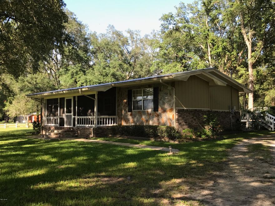 Picturesque 4/3 home in beautiful large oak setting.  Home has original hardwood flooring, split bedroom design, sweet tea front porch setting is a must see, 3 yr new metal roof and 3 yr new heat pump, nice back deck for entertaining by the above ground pool with out door shower, nice outside shop with 1 car garage and bathroom.  650 sq.ft. apt. currently rented , with detached laundry and storage area for rental. This is a must see to really appreciate.  Make an appt. today. Very convenient to Marianna and Tallahassee and I-10.