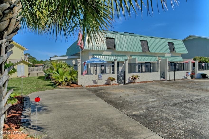 CURRENTLY UNDER CONTRACT, SELLER ACCEPTING BACKUP OFFERS. This is a single unit in a triplex. It comes fully furnished including a 65 inch big screen in the living area and flat screens in both of the Master Bedrooms (which have En Suites) and the spacious Bunk Room which is immaculate. The furnishings boast leather loungers, beachy artwork and décor. You won't need a thing. Just bring your toothbrush and your clothes. The best part, this is a simple triplex and there are NO Association fees! Included with this home is a Ring System with multiple cameras inside and out for your security. It also has an antenna system for V reception in the event of a cable outage. You have three full bathrooms, two storage areas and a stackable washer and dryer. The tiled back porch has a spectacular western view of Lake Riviera with its awesome sunsets. Talk about curb appeal? Driving up to this home you first encounter three beautiful Sable Palms and a Sago Palm which are all illuminated at night. Then you walk through the gated front entrance where you can grill your dinner or enjoy your friends around the fire pit. Plenty of room for loungers and umbrellas. A new metal roof and washer were installed in 2019. This has not been a rental. The unit is the one closest to the beach. Listing Agent will pay for a One year Home Warranty. This is a must​​‌​​​​‌​‌​​​​‌​​‌​​​​‌‌ see!!