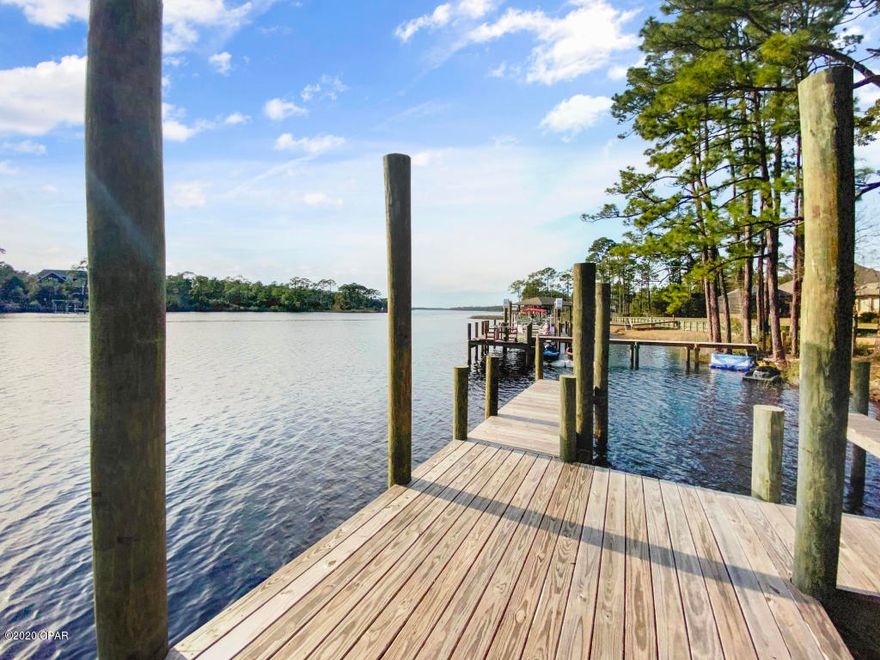 Beautiful new home right on Lake Powell and just a short boat trip to the Gulf.  When you turn into The Pointe at Lake Powell off of Wild Heron Way,   you know you are home.  This house features over 5232 SQ. FT.  three car garage, 4 bedrooms, 4 full and 2 half baths, 2 laundries, media room that could be 5th bedroom,  bonus room on second floor and as well on the third floor. This Executive home features cedar siding and stone work on the outside that just has to be seen and interior finishing that are just unbelievable with custom cabinetry including Wolf Sub Zero Appliances.  All this and right on the Lake with a oversize 1/2 acre lot facing West with beautiful sunsets views that features a boat dock. Jump in the boat and in just minutes, you are at the pass on the sandy white beach.