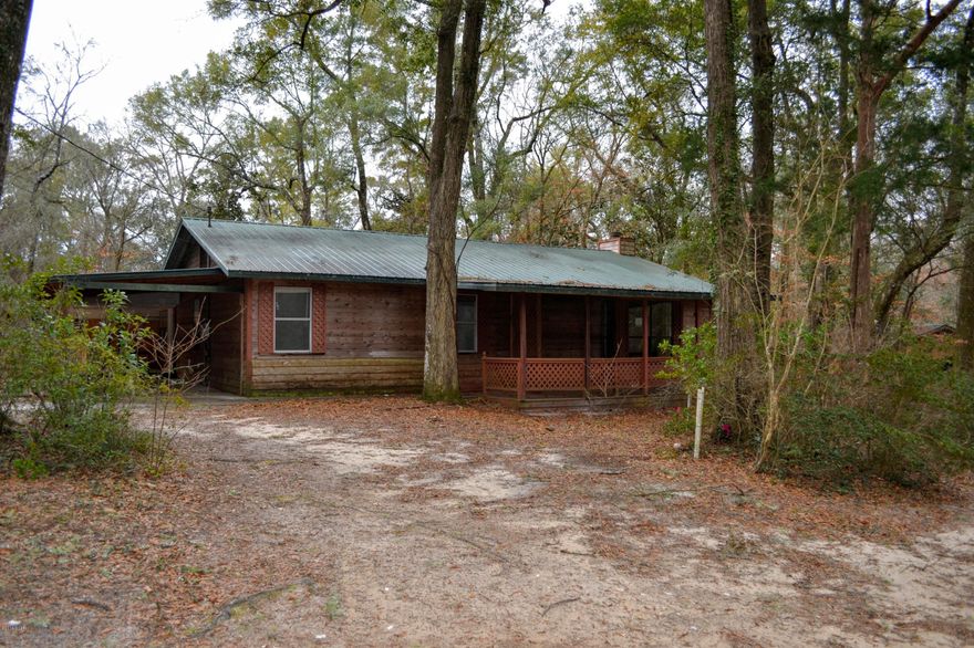 This incredible 3 bedroom 1.5 Bath home is located in secluded Econfina Estates just off hwy 20 and just a short drive to Panama City.  This home features an open floor plan with a gigantic living room kitchen combination complete with an inviting wood burning fireplace. open kitchen with island and quite a bit of cabinet and counter space, sizable master bedroom boasts a master bath with a fantastic sunken shower for 2, decks and walk ways encompass the home for outdoor living and entertaining and a 400 square foot, air conditioned, building complete with porch is Ideal for arts and crafts, a shop or would make a great game room.  The lot has many gorgeous hardwood shade trees to cool you down on those hot summer days.  The neighborhood has it's own exclusive gated park on Econfina Creek. The park provides covered picnic tables, BBQ pit and a boat launch area. Experience all that Econfina Creek has to offer.  Call your agent today to schedule and appointment.  All measurements, ages and room sizes are approximate.  Please verify if important.