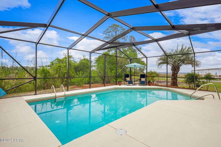 UNDER CONTRACT WITH CONTINGENCIES; SELLER ACCEPTING BACKUP OFFERS.

ASSUMABLE VA MORTGAGE AVAILABLE AT 3.25%.  TAKE ADVANTAGE OF A PAYMENT LESS THAN HALF OF TODAY'S RATE.
Welcome to 235 Moonlight Bay Drive, Colony Club, Panama City Beach, Florida, where coastal elegance meets functionality in this meticulously designed Cape Cod-style home. Boasting 2,856 square feet of living space, this residence offers an unparalleled blend of luxury and comfort. With 5 bedrooms and 4.5 bathrooms, including a conveniently located downstairs bedroom ideal for an office space or arts/crafts room, this home provides flexibility to suit your lifestyle.
Indulge in breathtaking northern views toward West Bay from both the first and second floors, offering panoramic vistas of boats traversing to and from Shell Island and the Gulf of Mexico. Enjoy leisurely afternoons by the pool, complemented by a massive 1,000 square foot pool deck with a protective cage, perfect for entertaining guests or enjoying serene evenings under the stars.

Crafted with durability in mind, this home features 2x6 framing, extra insulation, and Crane board siding, ensuring superior energy efficiency and peace of mind during inclement weather. Experience an abundance of natural light and stunning views from the spacious living/dining area, which seamlessly transitions to a pool deck oriented toward West Bay through elegant French doors.

The cottage-style kitchen boasts custom cabinetry, an island, and stainless steel appliances, creating a perfect setting for culinary adventures and gatherings with loved ones. Retreat to the downstairs master bedroom, featuring an en-suite bathroom with his and hers sinks and direct access to the pool area, offering a serene oasis for relaxation. Above the extra-large garage, discover a spacious bonus room with a bathroom, ideal for accommodating guests, a returning college student, or providing a private space for work or leisure.

Nestled on a large corner lot with a dead-end street on the north West Bay side, the pool area faces the Preserve to the north and west, providing enchanting views of the bay and lush forest teeming with wildlife. Enjoy the tranquility of a privacy-fenced area behind the garage and adjacent to the pool, surrounded by mature palms and flowering shrubs. Explore the bounty of nature with a beautiful fig tree adding to the charm of this idyllic property.

Colony Club is a family friendly neighborhood close to top-notch schools and walking distance to Gayle's trails, a short drive to Pier Park, Legacy golf course, great restaurants, and entertainment. Make this state-of-the-art home yours today.

Experience the epitome of Florida living in this meticulously crafted Cape Cod-style home. Contact us or your favorite Realtor today to schedule a viewing and make this coastal retreat your own!