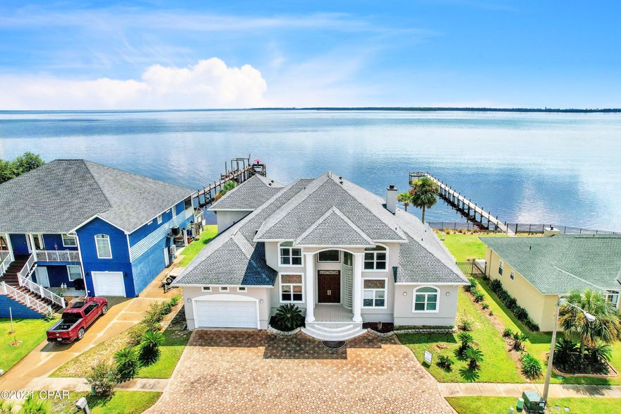 Under Contract, Taking Back Up Offers. Custom, spacious, 2-story waterfront home with beautiful bay views. Massive windows with solar control provide efficiencies and low utility benefits. Over 4,800 sqft. 3 New AC units in 2019 and new roof in 2019. New gutter system as well. House is freshly painted and has a new deck off back porch. The grand entry has a beautiful chandelier and a floating oak staircase with mahogany doors. High ceilings through-out this luxury home. Arched doorways and rounded corner. Living area has windows from floor to ceiling with a beautiful view of the bay. The master bedroom has an awesome view of the bay through 3 bay windows, and the bathroom has a garden tub, double vanity, and a separate tiled shower. Another 1 bedroom and 2.5 baths are located downstairs.  Kitchen has solid tall cherry cabinets and granite countertops and matching granite backsplash. Kitchen also has separate butlers' kitchen with range, vent hood, and sink, that can be closed off to the full kitchen for preparing food while entertaining. Living room, dining room, kitchen, breakfast nook, study, downstairs and spacious upstairs recreational areas. Some of the upstairs bedrooms have balconies overlooking the bay.  The seawall is vinyl and will not rot like wood.