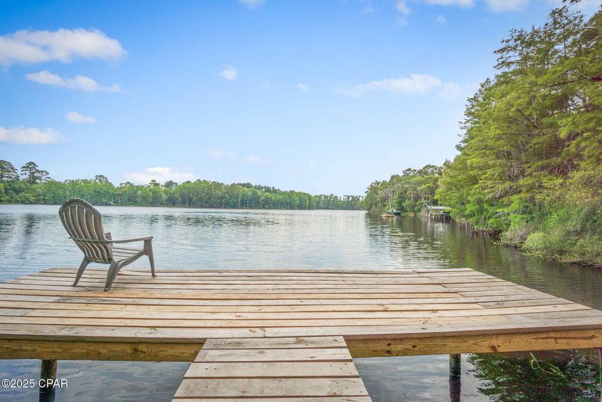 Discover a one-of-a-kind waterfront estate on 6 acres extending into Lake Bowen (a natural spring fed lake) offering unparalleled privacy, recreation, and unspoiled beauty. With approximately 1,200 feet of pristine shoreline and direct access to three lakesfrom your own property, this hidden gem is truly a sportsman's dream, a nature lover's oasis with abundant wildlife, and an entertainer's haven all in one.

Enjoy multiple panoramic lake views with water on two sides of the property, and world-class duck hunting just two minutes from your private dock. A custom Steel City bridge (80ft long X 4ftwide) connects two sides of the property, creating a seamless flow between outdoor spaces.

Outdoor Features Include:

• 5 private docks, including a floating dock
• 2 entertainment platforms, one with a pergola and gas fire pit
• Boathouse (Can accommodate a 20 ft boat)
• 2 outdoor wood-burning fire pits
• Mature oak trees and lush, landscaped grounds
• Private stone column entrance with long driveway
• Sprinkler systems, deep water well, and chain-link fencing
The 2-story stucco home is approximately 1,650 sq ft and was built with quality and durability in mind-every fourth block is concrete-filled for enhanced structural integrity. Inside the home offers:

• 3 bedrooms, 2 full baths
• A vaulted great room with a ceiling 16 ft tall spans the width of the home.
• Gas fireplace in great room
• An open loft overlooking the great room
• Expansive wraparound deck with stunning lake views
• 3-car garage with 1,162 sq ft
• Utility building (12 ft X 16 ft) enclosed plus 2 bays which can house your John Deere tractor, implements, and riding lawn mower. 
This private retreat is ideal for boating, fishing, hunting, and entertaining and only minutes away from Northwest Florida Beaches International Airport and Panama City Beach. Truly a once-in-a-lifetime opportunity for those seeking seclusion, tranquility, and unmatched lakefront living.
****** The last two pictures are of another area on the lake that you can take a boat ride to. It is not part of this property******
