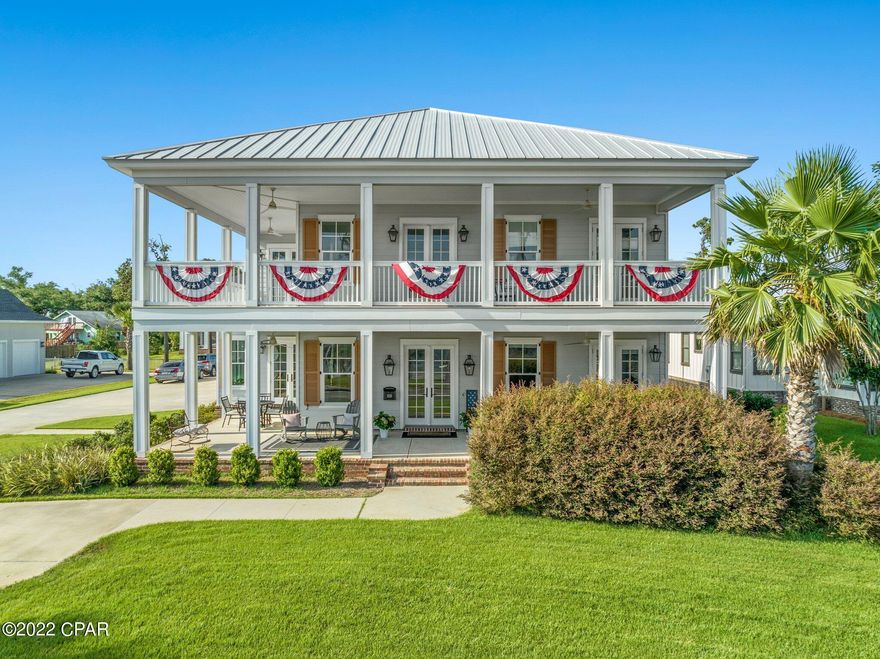 BAYFRONT LIVING! Ideally located within minutes of Downtown Panama City and St. Andrews, this waterfront home is an entertainer's oasis. Outdoor spaces are plentiful with a double wraparound porch, private pool, outdoor shower, gas fire pit with granite top, porcelain tile pavers on pool deck, and outdoor kitchen. The covered outdoor kitchen comes equipped with a gas grill, granite countertop, storage, built in trash, and a half bathroom. 

The interior is immaculately maintained with 10 ft ceilings, engineered hardwoods throughout entire home and includes two separate living spaces, laundry room, wet bar and stair access to attic storage. 

No detail was missed in the stunning chef's kitchen featuring built in appliances, waterfall edge kitchen island, farmhouse sink, and pot filler. Off the kitchen is the breakfast nook with a built in bench and french doors that can open up to an additional outdoor dining area. The main level also includes a formal dining room and a library with beautifully crafted built in bookshelves and 12 ft coffered ceilings. The Owner's Suite is on the first level and has bay views with french doors leading to the front porch. Owner's bath is spacious with double vanities, an elegant claw foot soaking tub, separate tile shower, and walk-in closet. Upstairs is another living space in its own, with a large secondary family room, two additional bedrooms with their own en suite bathrooms, and access to the wraparound balcony from every room. The property also includes the beach lot across the street, no docks are allowed to be built. All important information must be verified by buyer.