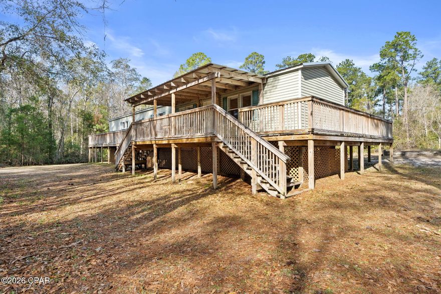 Welcome to 6919 Nellie Whitfield Rd in Wewahitchka - a property that delivers space, privacy, and the kind of setup serious hunters and outdoor enthusiasts appreciate. This property has serious short term rental possibilities,

This elevated home is surrounded by natural woods and wide-open land in the heart of North Florida. With multiple freshwater boat launches and a nearby wildlife management area in Howard Creek, prime access to hunting, fishing, and year-round outdoor recreation comes easy. Whether you're chasing deer and turkey, running dogs, or heading out to nearby rivers and creeks, this location puts you right where you want to be without sacrificing comfort. Spend your mornings in the woods or on the water, then head back home to reset and recharge.

The home features expansive wraparound decking, including covered sections that are perfect for early mornings, gear prep, or unwinding after a long day outdoors. The elevated design provides added durability and airflow, while the space below offers practical covered storage for equipment, coolers, and tools.

Inside, the stone fireplace anchors the main living space, creating a solid, lodge-style atmosphere. The kitchen and dining area are built for function - plenty of storage, stainless appliances, and room to fuel up before the hunt or host a post-season cookout. Natural light and multiple access points connect indoor living seamlessly to the outdoors.

The covered pole barn/workshop is a standout feature ideal for boats, ATVs, trailers, tractors, or a dedicated workshop. There's room here to store what matters and work on what you enjoy.

Located in Wewa, this property offers true rural freedom with easy access to surrounding hunting land, waterways, and back roads - while still being a manageable drive to town amenities and the Gulf Coast. Port St. Joe and Mexico Beach are just a short drive away, offering deep-water fishing, dining, and Gulf Coast adventures - giving you the best of both worlds: quiet country living with coastal access when you want it.

If you're looking for a property where the land matters, the access matters, and the lifestyle matters, this one delivers.

6919 Nellie Whitfield Rd, where your weekends start and the outdoors come standard.

Schedule your showing and see what this property has to offer!
