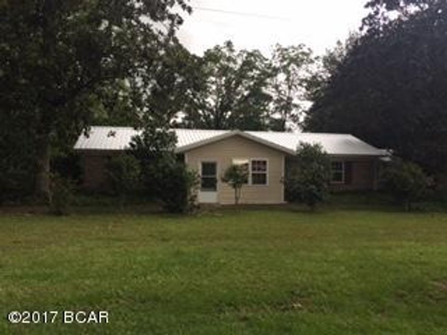 Come see this spacious 3BR/2BR country home with lots of updates!! Move in ready. New flooring, windows, interior paint, metal roof just installed, bathrooms updated and lots more. Extra large laundry room, sitting area at front of home, oversized living room, den, and a dining room. Outside features are a carport, concrete patio and a beautiful yard with pecan and fig trees. Plus beautiful magnolias and camellia bushes all with paved highway frontage.