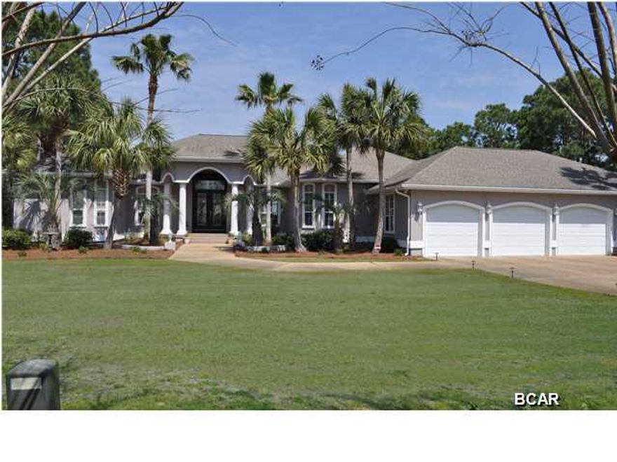 *Sellers offering a buyers allowance or credit of $100,000 for customizing to buyers taste.*  This is a rare find in Panama City Beach; over 4.3 acres on St. Andrews Bay with a magnificent and move-in ready home. Custom built in 1998, this incredible 5BR/3BA home has approx. 350' of waterfront with a boat dock and slip for a large boat, a screen-enclosed lanai and pool, and a 4 car garage. Your success will show in every room of this luxury home. Featuring an open-floor plan, there are several sets of French doors that open to the lanai and pool area and numerous windows that offer that gorgeous water view. The large upscale kitchen has custom Cherry wood cabinets galore with roll-out shelves, a Jenn-Air range in the center island, a huge walk-in pantry and a custom designed wet bar. You'll appreciate the panoramic views of the water from the Great Room along with the gas log fireplace. There is a formal living room with coffered ceilings and a formal dining room with grand chandelier and a built-in buffet. The home boasts split-bedrooms with the Master Suite overlooking the lanai/pool area and of course the bay. The en suite includes double vanities, a whirlpool tub and a walk-in closet the size of a bedroom and has integrated dressers and shelves help keep things neat and tidy. The 5th bedroom is next to the Master Suite and is currently being used as an office, but does have closets and could make an excellent nursery. The rest of the home has copious amounts of closet space and there's even a large storage room inside the garage perfect for storing your holiday decor. Included in the sale are custom fitted hurricane screens by Armor Screen and an electric roll down barrier to protect the front doors. Because of the lot size, there is plenty of room between the home and the water to build a carriage house, tennis courts and even a putting green! There are so many more features, but we don't have the time or space to include it all here. You need to see this property in person. This Grand Harbor home is part of a very small community of only 17 homes. If peace and prestige are what you seek, then look no further than this stunner. This property has an R-1 urban zoning classification with many options.  All info is approx. and must be verified by Buyers if important.