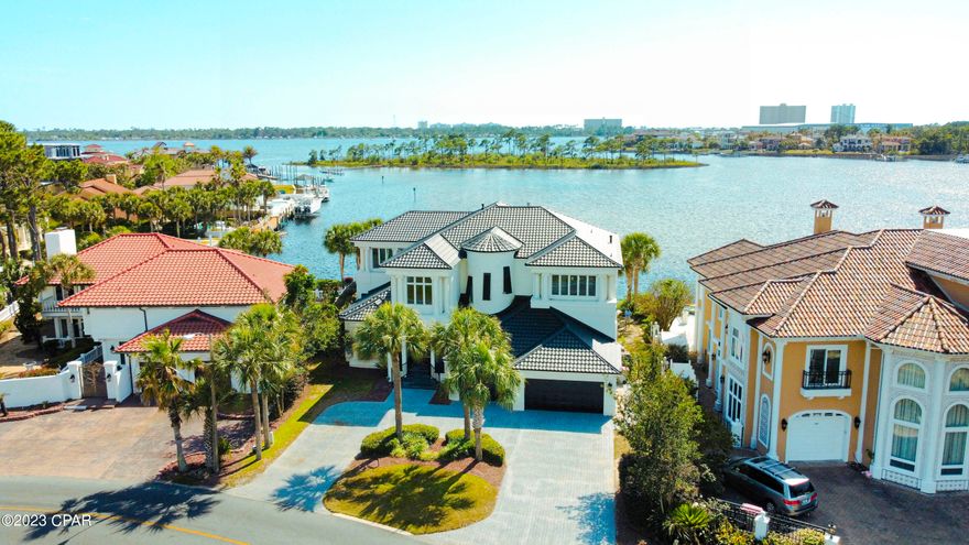 CURRENTLY UNDER CONTRACT, SELLER WILL CONSIDER BACKUP OFFERS. This passage describes a modern American home designed to evoke a sense of wonder, with exquisite finishes and breathtaking views of the Grand Lagoon from all angles. The property has 106 feet of deep-water frontage, a backyard dock, and a heated pool that offers indoor-outdoor living. The owners recently installed a changing room for your convenience when you are lounging around at the pool. The chef's kitchen features a waterfall black-honed granite center island and other high-end features like double ovens and a subzero. The main floors are adorned with marble of various depths and colors, while the master and second levels have contrasting black wood floors. The 3-car garage provides ample parking space and a circle drive with room for more parking as needed. 

Upstairs is a second master with a balcony, a game area, and additional bedrooms and guest suites with sitting rooms, balconies, and custom closets. This property's location is in the gated community of Bay Point, a guarded community with easy access to St Andrews Bay and the Gulf of Mexico. The site is ideal for fine dining, yachting, tennis, and golf. If you like to get involved in social clubs, we have so many to choose from, like The Yacht Club, Bay Point Women's Club, etc. This community is a lifestyle, and you will love all it offers.

The owner replaced the roof recently, installed new hurricane shutters on the outside windows, and installed a whole house generator—so many additions since they have owned the property. I have a list on file.