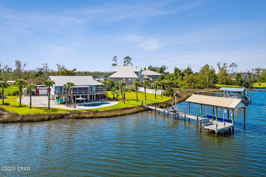 Gorgeous waterfront home that's as close to paradise as you can get.  As you enter through your private security gate fresh beautiful landscaping abounds with breathtaking views of the deep waters of Cook Bayou and East Bay. Along with the views is your own private salt water pool that adds a spa like serenity to this little piece of paradise.  Entering the home, you will immediately notice the bright open floor plan of the living room, kitchen and dining area. The soft wall colors, natural light and beautiful tongue in groove ceilings create a relaxing environment that makes this cozy home feel comfortable and inviting.  Prepare your meals in the beautiful, as well as functional kitchen while admiring your waterfront view.  The large primary bedroom has sliding glass doors that lead out to the balcony and screened in porch that overlooks the bay and pool.  The primary bathroom will take your breath away with its spa like feel, with glass walls, double vanity, and tiled shower.  On the way to the dock, you will find the recently added 12,000 gallon salt water heated pool with water feature and LED lights.  Continue down the composite wood dock to find the covered boat lift with electric motors and a newly installed jet ski lift.  Imagine ending your day relaxing on the custom-built bench at the end of the dock watching the dolphins play and birds feed as the sun sets and delivers an unimagined beauty. Every upgrade in this home was carefully thought out and designed for efficiency, functionality, and energy savings from the seamed metal roof to the Bosch air conditioning system. Large oversized work shop with electricity and a lean-to on both sides is great for the hobbyist or craft enthusiast.  If you're looking for beautiful property that provides amazing access to water sports and some of the most stunning sunsets around, then you have found it.