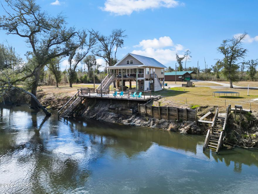 CURRENTLY UNDER CONTRACT, SELLER WILL CONSIDER BACKUP OFFERS. This sought after Chipola River home is being offered at a great price!!  This 2BR/2BA home is the perfect get away!   The A-Frame design's high cathedral ceilings give this home a spacious feeling.    This home is a perfect Airbnb bringing in a yearly income of around $35,000 yearly.  The porch and large deck are perfect to enjoy the serenity of the river and its surroundings.  The outdoor areas are spacious including the covered front porch, the large deck just steps below to the dock located at the water.  This offers easy access to the river for docking boats or just jumping right on in!  The middle deck is perfect for sunning or firepit nights under the starry skies.  If the sun is a little bright, the covered porch is going to be just right.  Not to mention, there is an outdoor cook area and restroom under the home with extra storage.  This parking space is even large enough for your pontoon boat!  If you are an avid fisherman or just want to lazy river float down the river, the Chipola River is the perfect place to be!  Don't miss this opportunity to own a little slice of heaven!