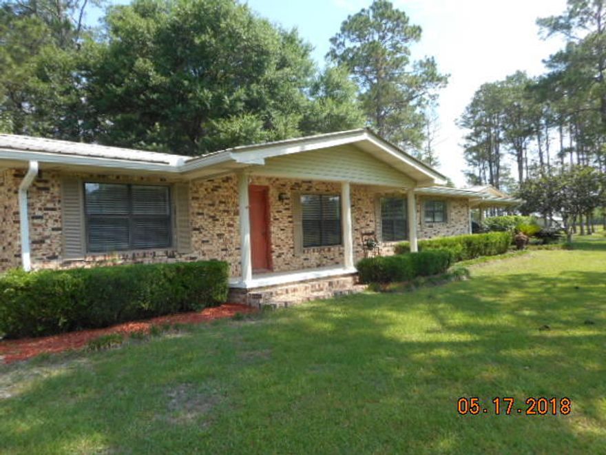 REDUCED!! Spacious brick home,9.25 acres,Hwy 90, Ponce de Leon + bonus building,used as business. Main home is 3 bedrooms, 2 baths. Master bath recently updated with new fixtures, including new shower and tile floor. Hall bathroom has handicap compliant door. Large cozy great room holds kitchen, dining area and plenty of room for office desk. French doors and lots of windows bring the outside inside when you step into the tiled Florida room.Ideal spot for morning coffee or relaxing. Living room is spacious. Original hardwood floors in BR's beautifully refinished. Window blinds stay. Two central heat and air units. Metal roof. Extra large carport. Exit back door to enjoy sunshine on patio. RV connection with electric & water in back yard. This home is conveniently located in city limits