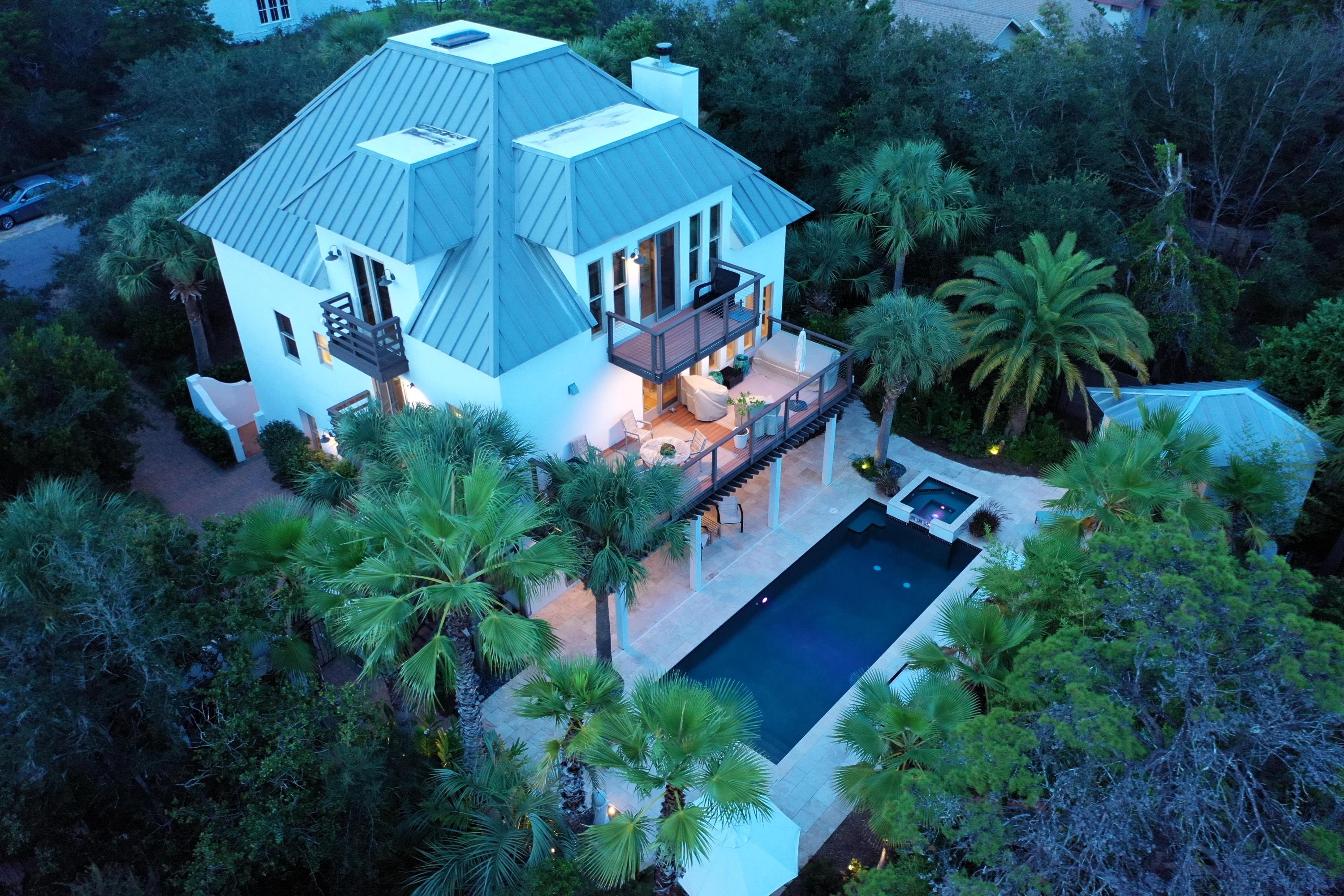 This very special home presents an architectural masterpiece enhanced by the privacy and beauty of its natural surroundings, making everyday life feel like a nature retreat! Enjoying a desirable location off of South Walton's Scenic Highway 30A, the home offers three stories of unique and artistic spaces designed for fabulous gatherings and relaxing personal spaces. Plus the incredible backyard oasis is like being at a tropical spa! The main level centers around the stunning great room with soaring beamed wood ceilings, a wood-burning fireplace, and beautiful white oak floors. It is open to the dining room, which enjoys fabulous natural light, and the kitchen. The kitchen includes a butcher block-top island, stainless appliances--among them a Subzero fridge, Bosch oven, Fivestar