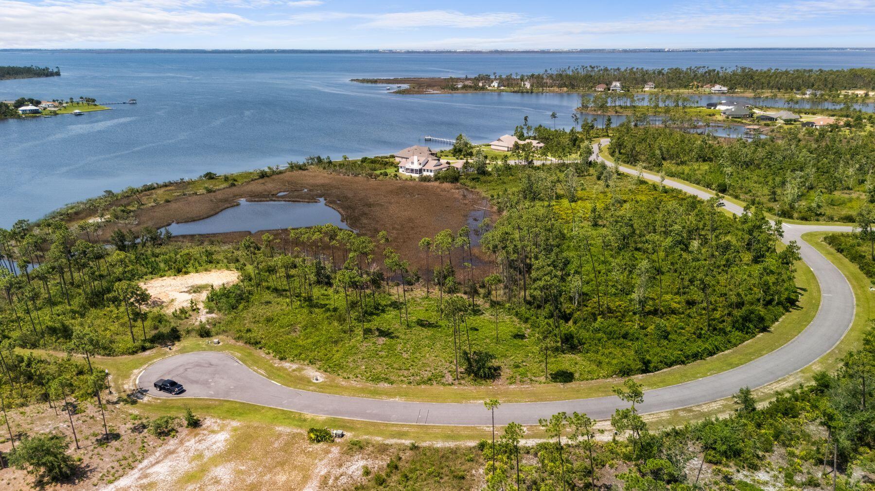 Positioned on a generous stretch of waterfront, this remarkable homesite offers unspoiled bayou views and a tranquil sense of retreat. Set within a secure gated community on a natural peninsula between Laird Bayou and East Bay, the property invites you to create a dream home framed by serene water and lush coastal greenery. Residents enjoy the kind of privacy and peace that's increasingly rare, along with well-kept roads, underground utilities, and a close-knit, walkable environment where dogs and neighbors alike are welcome. Community amenities include a private boat ramp and dock, a sparkling pool with bathhouse, a charming gazebo, and dedicated RV and boat storage--everything you need to enjoy life on and off the water. Spend your mornings paddling along glassy bayou inlets and your evenings watching the sun dip low beyond the treetops, all while being just minutes from the shops, restaurants, and everyday conveniences of Panama City. Whether you're ready to build now or looking for a future homesite that offers both sanctuary and connection, this exceptional lot delivers the rarest of combinations: natural beauty, modern amenities, and a community that feels like home.