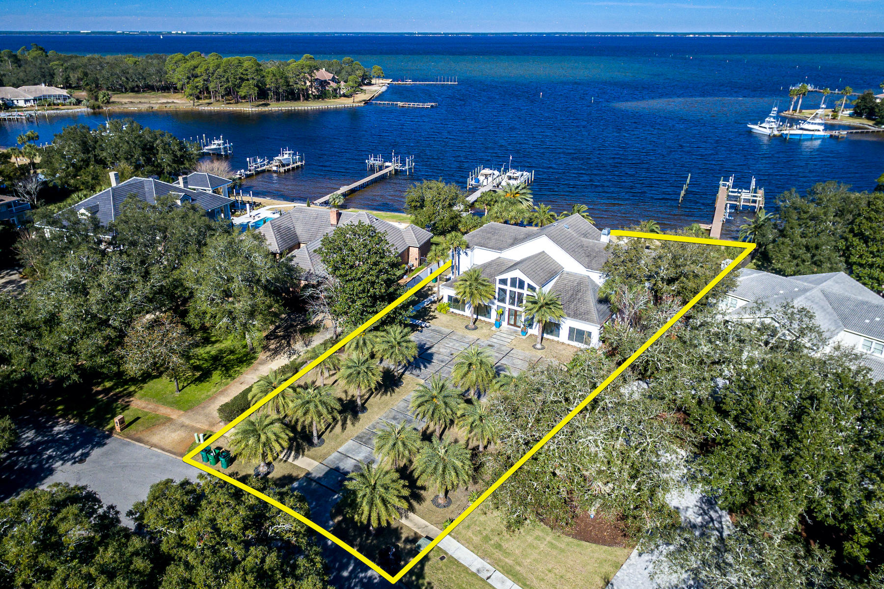 Spectacular contemporary home with 138' feet on deep-water Indian Bayou directly across from Choctawhatchee Bay! This gorgeous residence features a 2+ story wall of windows for stunning water views and abundant natural light throughout. The huge living/dining/bar area is fabulous for entertaining, especially as it leads directly out to the large patio, pool, yard, and boat dock.    Impeccably designed, the finishes are beautiful, functional, and decorative. Of special note is the incredible cabinetry throughout the home, which beautifully keeps to the home's contemporary theme, ensuring a clean, minimalistic feel while providing an amazing amount of storage capacity! The floorplan is perfect for modern lifestyles. Just off the dining area is the fantastic European-style kitchen...