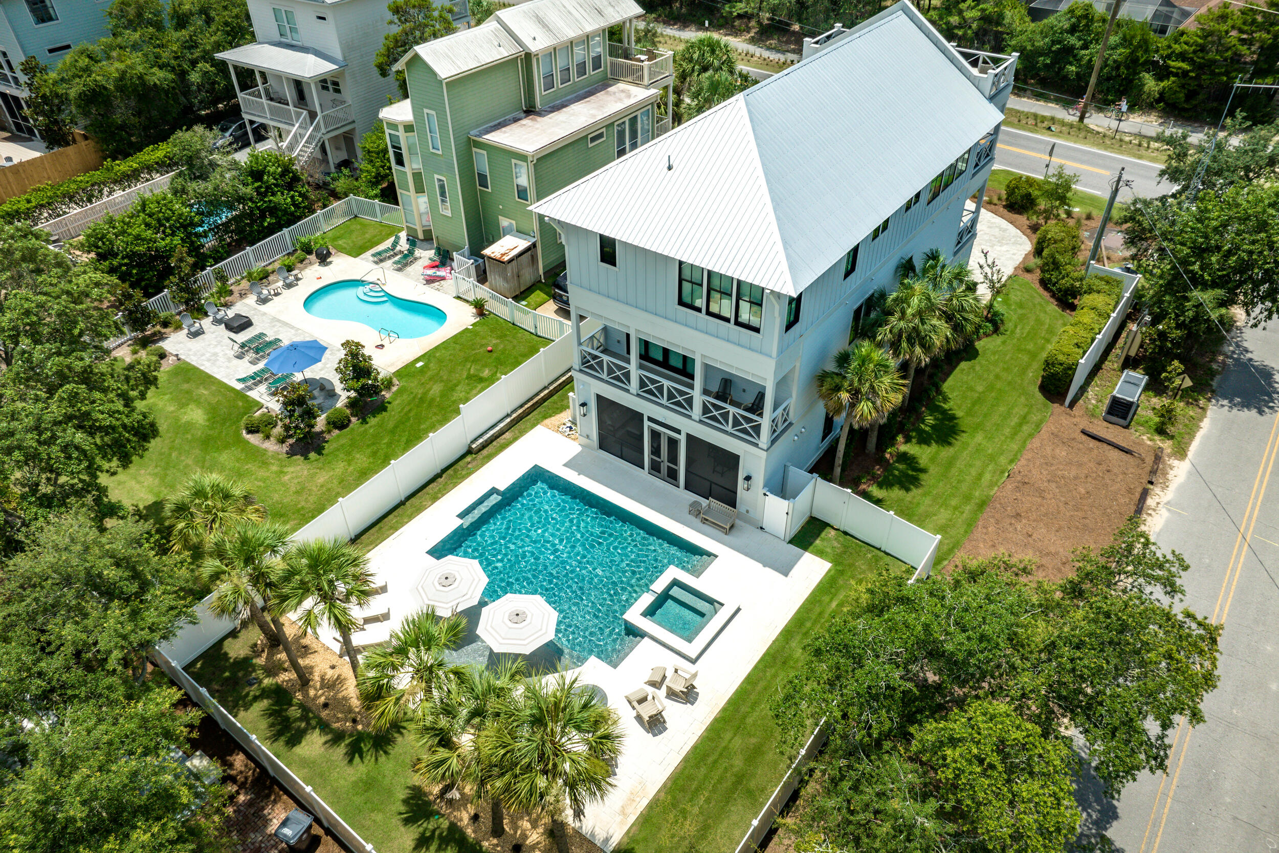 Step into a stunning 2023 newly constructed, never rented home directly on 30A, designed for luxurious coastal living and effortless entertaining. Nestled on a spacious corner lot, this thoughtfully designed three-story retreat boasts one of the largest private pools on 30A, a rooftop terrace with panoramic Gulf and Camp Creek Lake views, and nearly 1,840 sq ft of outdoor porches and living space. Whether you're relaxing or hosting, every detail of this home is elevated and intentional.An elevator provides easy access to every level, from the expansive first-floor entertainment areas to the top-floor main living space, where 18' vaulted ceilings, exposed rustic white oak beams, and custom oversized windows frame breathtaking Gulf and dune lake views. The open-concept living room is anchored by a striking floor-to-ceiling fluted tile fireplace, a 65" TV, SONOS soundbar, and a pair of sliders that lead out to a large covered deck and rooftop terrace. A spiral staircase offers additional access to the 4th-floor rooftop, ideal for sunset cocktails or morning yoga.
The gourmet kitchen is a showpiece with a massive 130" x 60" charcoal suede Silestone island, paneled oversized refrigerator/freezer, Thermador appliances, Blanco Silgranite sink, Zellige tile backsplash, and Kelly Wearstler designer pendants. A built-in wet bar completes the space, making entertaining seamless.
The first level includes a spacious game room with barn door entry- easily converted into an additional bedroom- with a full bath featuring a gorgeous concrete trough sink and walk-in shower. Slider doors lead to the screened-in outdoor kitchen and living area, which includes a NatureKast 60" grill, Blaze refrigerator, and an 80" TV overlooking the show-stopping custom Gunite pool and spa, designed with sundeck, bubblers, spa jets, PebbleTec finish, and Hayward automation.
A built-in drop zone near the pool provides the perfect place to stash beach towels and outdoor gear after a day in the sun. The primary suite, tucked privately at the back of the home, is a true sanctuary featuring a wood accent wall, beamed ceiling, stylish pendant lighting flanking the bed, and slider doors that open to your backyard oasis. The primary bath offers a spa-like experience with a freestanding soaking tub, custom inset cabinetry, Silestone quartz countertops, and beautiful tilework throughout.
On the third floor, the junior primary suite rivals the main suite in luxury, with its own beamed ceiling, wood accent wall, and designer finishes. All bathrooms throughout the home include Delta fixtures, under-cabinet lighting, and high-end tile selections.
Additional features include:
- 10' ceilings on every level
- Two laundry rooms for convenience
- Sierra Pacific FeelSafe hurricane-rated windows and sliders
- Three Carrier Infinity HVAC systems with WiFi and Ideal Humidity
- Automated Alta Bliss shades in all bedrooms, game room, dining area, and stairwell
- Full home SONOS speaker system in kitchen, living room, decks, porches, and primary bath
- Smart wiring, a security panel, and outdoor video surveillance for peace of mind
This one-of-a-kind home perfectly blends modern coastal elegance with comfort and practicality- all directly on Scenic Highway 30A. Whether you're entertaining guests, enjoying quiet mornings by the pool, or taking in the Gulf breeze from the rooftop deck, this property is built to impress at every turn.