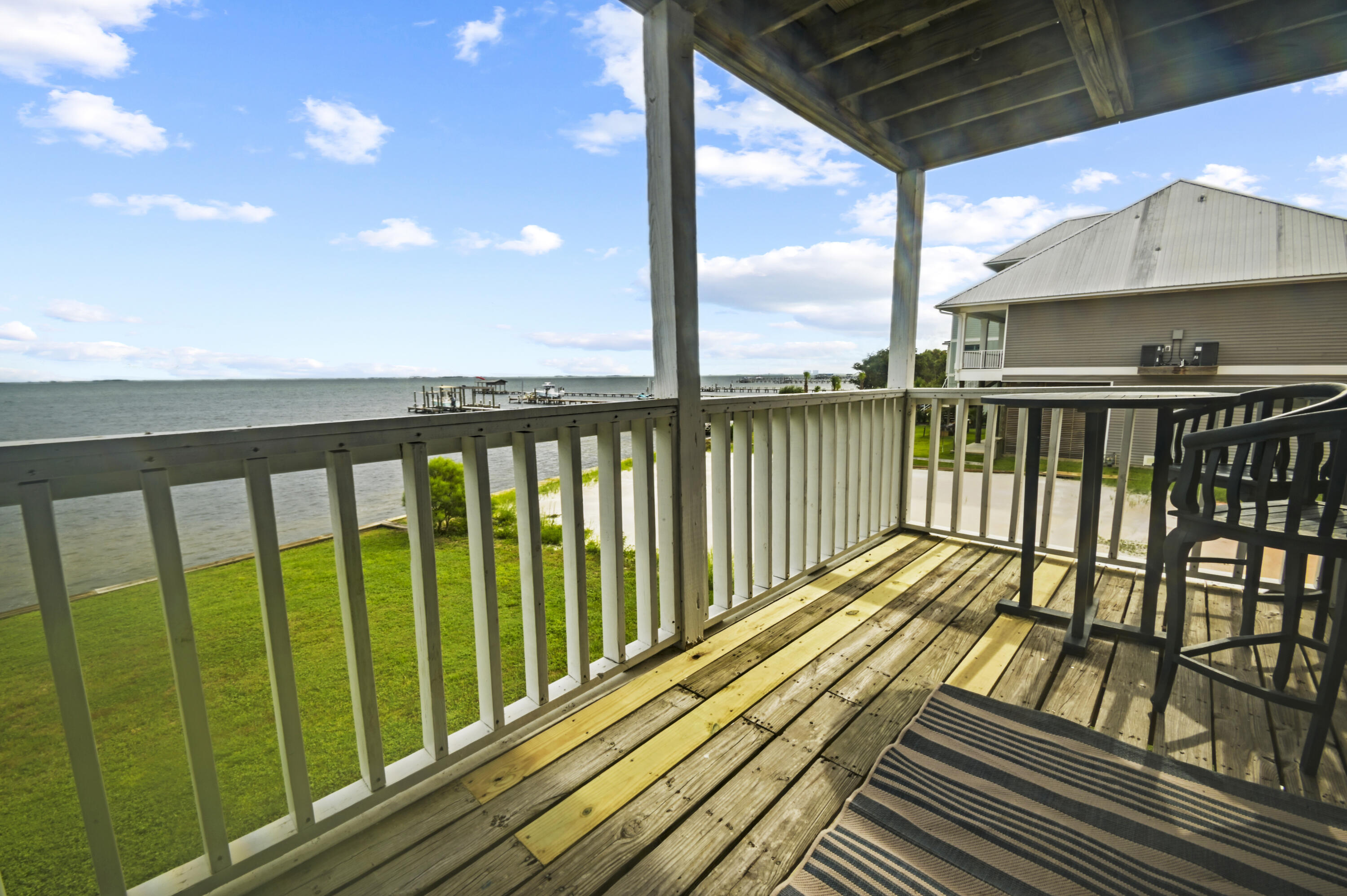 Welcome to this fully furnished, CORNER unit condo located directly on the Santa Rosa Sound. This beautiful condo offers a quiet coastal escape while still offering urban conveniences nearby in Gulf Breeze and Navarre. Stepping inside you are immediately greeted with unobstructed waterfront views from the corner-unit balcony. The split design provides privacy with the bedroom in the front of the condo, the updated bathroom in the center, and the living/dining area in the rear. The kitchen is spacious with abundant storage and all the appliances were recently replaced. The crown jewel of this condo is the MURPHY BED creating an additional bedroom for guests out of the living room. Stepping through the sliding glass door, relax with a coffee overlooking the scenic sunset views over the water. This unit includes two parking spaces and a spacious storage room. Community amenities include a newly replaced pier, a picnic area, a ladder to the water for swimming, canoe/kayak storage, boat docking, and a dry boat slip. Just down the road is a public boat launch as well! This condo provides a serene coastal escape unlike any other on the Emerald Coast, so stop by and make your waterfront dreams come true!