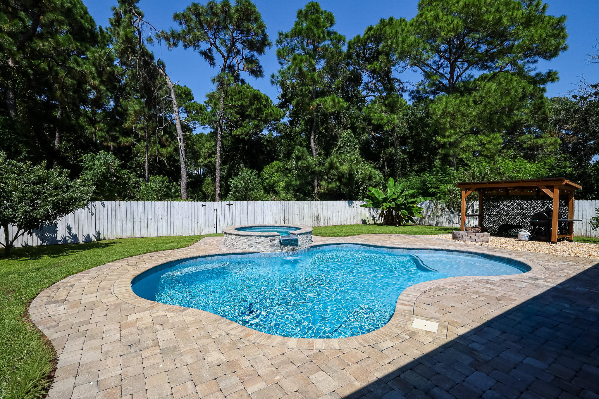 Beautiful 4 bedroom, 2 bath home available in east Navarre. This property offers a functional layout with an open living and dining area, spacious kitchen, and split bedroom floor plan.The kitchen includes stainless steel appliances, granite countertops, and plenty of cabinet space. Wood laminate flooring runs through the main living areas, with tile in wet areas and carpet in bedrooms. The primary suite features a tray ceiling, double vanity, separate shower, and spacious walk-in closet.The fenced backyard is designed for year-round enjoyment with a pool and hot tub (pool service included in rent), covered pergola for grilling or outdoor dining, and a fire pit area. Yard is equipped with a sprinkler system for easy maintenance. Pets may be considered with owner approval and a non-refundable pet fee. Smoking and vaping are not permitted.