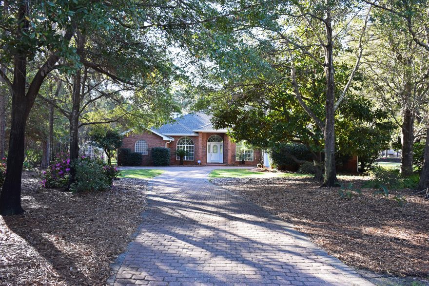 Sparkling with personality! This one-owner brick contemporary is ready for YOUR family! Sited about 70 feet back from the road and accessed by a tree-lined driveway, it feels as if you are entering a mini-estate. The back of the entire home is glass so you will enjoy not only views of your lush backyard, but also the 5th fairway of the golf course.
To enhance an open, airy feeling, the front of the house was designed with graceful arched windows. The great room features a 10' ceiling. The study and dining rooms offer additional 1' trays again creating a feeling of openness. You'll love the updated eat-in kitchen with its brand new granite countertops and bright white cabinetry. The high bar serves as a casual eating area and blocks your guests' view of your food prep space! The stainless appliances, including the LG convection range with double ovens, date from 2011.  A pretty Tiffany-style lamp accents in the dining area. 
The highlight of this delightful home is the 1062 SF Florida room with its cathedral ceiling and floor- to-ceiling, Xenon-filled, low-E,140 mph-resistant  windows.  The panels on the walls are 6" thick. Tiled with slate-look porcelain tile and heated and cooled by 2 commercial-grade mini-split heatpumps, this sun-bright space brings the outside in.  You'll love the way the indoor light changes as the day progresses.  Even rainy days can be special from this wonderful room.  The owners set aside a corner for their pet birds--a floor- to- ceiling screened area with a water hose and and drain-- accented with colorful parrot paintings. Even if you don't have pet birds, this enclosure would work well for other kinds of pets or even as an indoor gardening area.  
The master suite offers not only a sleeping area but also a bonus space with multiple uses (office, nursery, exercise room).  There are his and hers walk-in closets leading into the cathedral-ceilinged bath where there is ample space for two people to get ready for work or for a night on the town.

The additional two bedrooms and bath are on the opposite side of the house, away from the busy living areas and close to the laundry-- a pretty sensible arrangement.  Both are oversized compared to standard kids' bedrooms so they could be shared.  
The oversized garage easily holds two vehicles and a golf cart.  There is room for other things like bikes & lawn equipment. There are also pulleys for hanging your kayaks.  The attic space is floored; there are wooden panels for storm protection for the front window. Also a handy sink.

Practical facts:
1.  10-zone sprinkler system with a lawn pump
2.  Citrus trees, blueberry bushes, blackberries, raspberries, muscadine grapes and more all grow in the backyard so you'll really enjoy the greenhouse.
3.   Amana gas/electric heat and air system complete with a UV filter was installed in 2013.
4.  All duct work cleaned in 2014 and ducts re-sealed.
5.  Hot water heater- 2014
6.  Interior painted in 12/16.
7.  Carpets date from 2013.  Freshly cleaned.
8  Dimensional roof installed in 11/2016 

EXCEPTIONAL is the best word to sum up this feature-filled, family-friendly HOME!!  See it today!