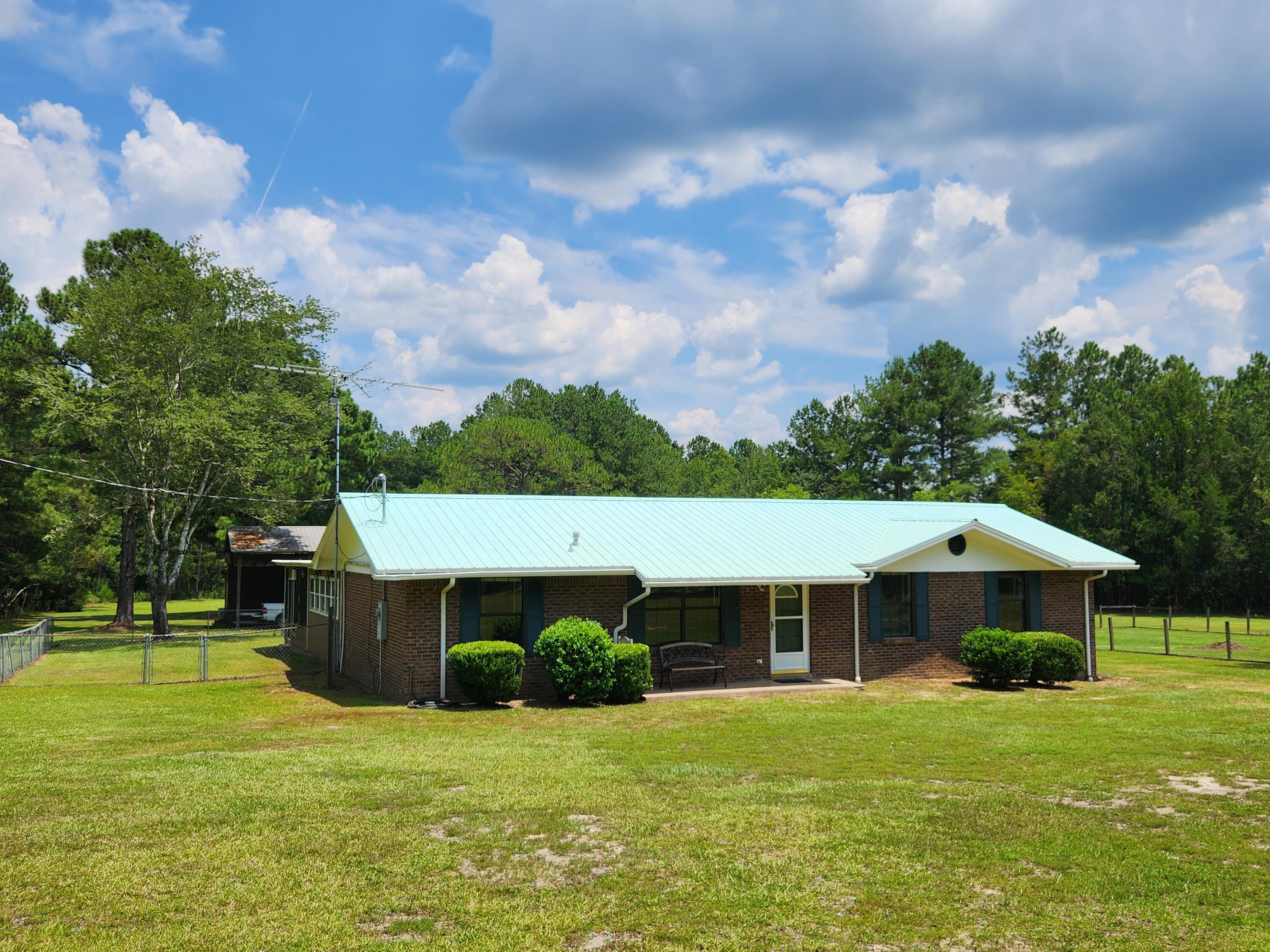 **Private and secluded 1-story brick ranch home on 5 acres for under $300K!** Wonderful brick ranch home with a metal roof situated on 5 acres is conveniently located only a few miles from I-10 and Hwy 177. No subdivision or HOA dues to worry about! This home and property include several improvements and additions by the current owner. Featuring 3 bedrooms, 2 1/2 baths, kitchen with eat-in area, family room, dining room, laundry, sunroom, screened porch with cooking area, detached shop/garage, 2 separately fenced areas, a lighted basketball half-court and a pole barnincluding an attached finished heated & cooled game room, this secluded retreat offers something for everyone. There is an unbelievable amount of storage space in the shop/garage as well as the covered/enclosed pump house.