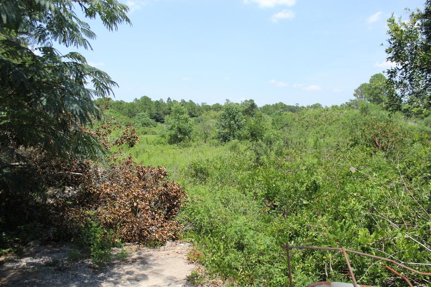 Lot is only piece of industrial land available in south Okaloosa county. It is mostly wooded with some construction materials sitting towards the back of the lot.