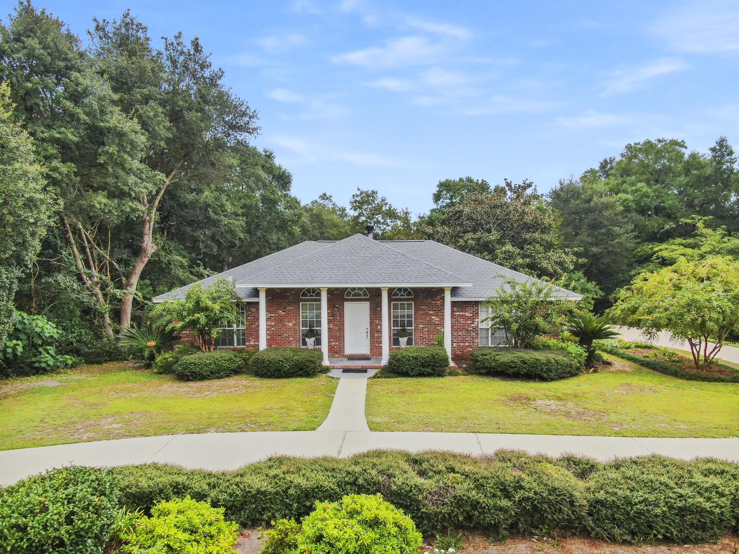 A garden paradise awaits you! This 2003 home got a major facelift. It has a new roof, powder coasted Carrier HVAC, and two new hot water heaters. Enjoy quiet country living with no active HOA. An inviting front porch and foyer leads to an open concept living room with high ceilings, down lighting with dimmers and a wood burning fireplace. The kitchen has unique granite countertops and backsplash with stainless steel, touch screen appliances. The dining room has two built-in china hutches. The flooring is tile throughout with solid wood flooring in all three bedrooms. The owner's suite has a double shower and walk in closet. Relax in the enclosed sun room that leads to a secluded courtyard with flower gardens. Each garden has automatic lighting and a watering system. Refresh yourself in a