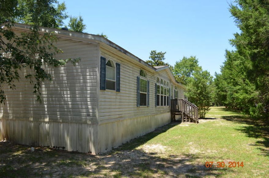 This large mobile has tons on potential! An oversized home this property has 2 open decks directly off of each side of the kitchen, a master bedroom that is large enough to fit most any furniture and a master bathroom with garden tub, walk in closets, separate shower and a his and her separate commodes. A split bedroom design, the remaining 3 bedroom are on the opposite end of the home. Bedrooms 1 and 2 share a second bathroom, and there is a 3 bathroom for guests. Living room has a fireplace and is large and open. As well there is a a family room with fireplace as well. Home needs some TLC but could certainly make a great home or rental for investor.