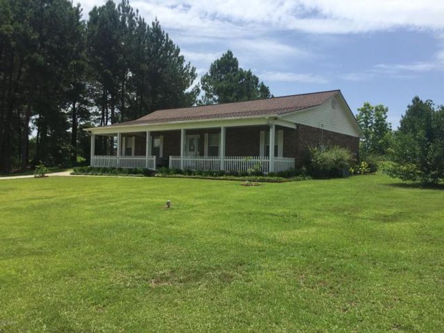 If you are looking for your own gated oasis be sure to include this lovely 3 bedroom 2 bath home that sits on 1.3 beautiful acres. The Seller is Gifting you a Home Warranty with this custom brick home that features a large front porch that leads into a spacious living room with lighted tray ceilings and solid wood flooring and a gorgeous entertainment center just waiting to house your flat screen TV. You will find lots of room and cabinet space in the kitchen that also features lighted tray ceilings, granite countertops, ceramic tile floors, and stainless steel appliances. The dining room has French doors leading outside to a nice sized patio that is perfect for sunning and grilling. The home features split bedrooms for the convenience of parents and children and the Master Bedroom