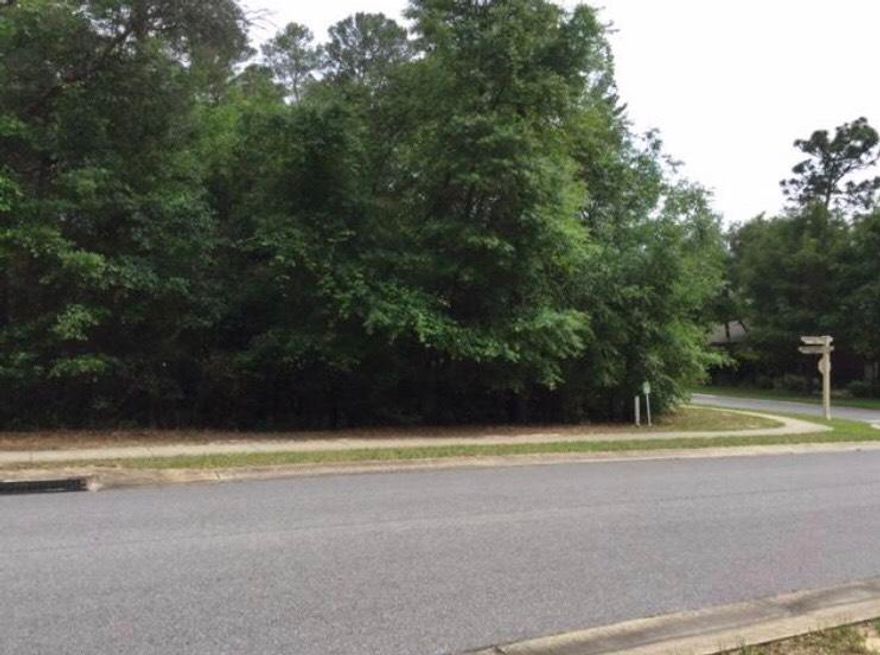 Large, flat corner lot with mature tree and sidewalks.