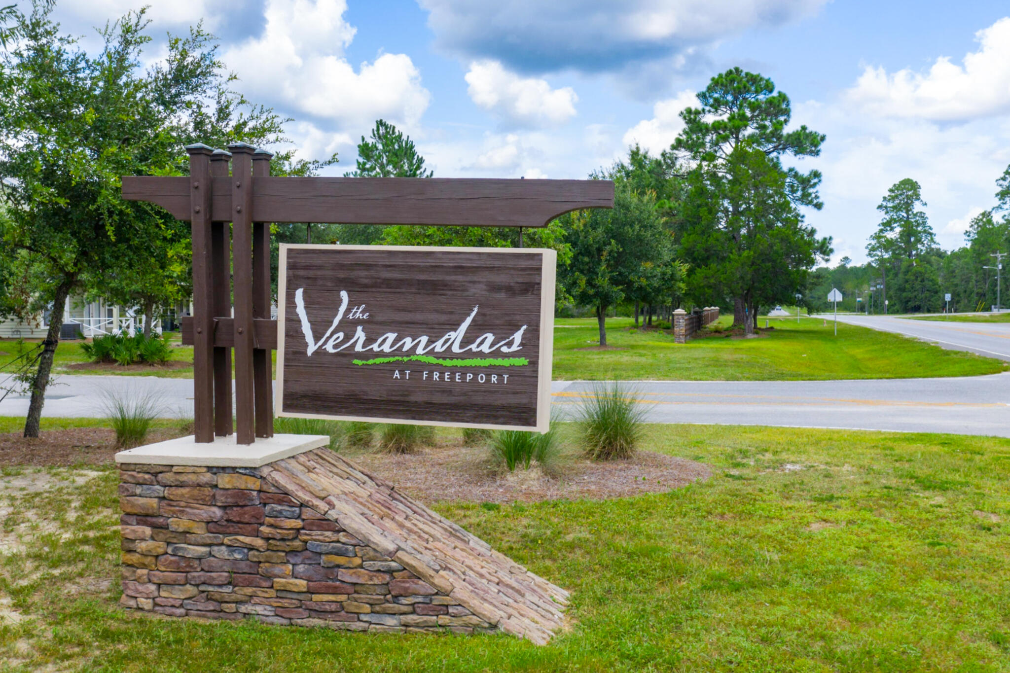 Premium end-unit townhome located in The Verandas at Freeport, offering abundant natural light and a spacious lot with wooded views for added backyard privacy. This 3-bedroom, 2.5-bathroom home features luxury plank flooring throughout, 9-foot ceilings, and an open-concept layout that flows seamlessly between the living room, kitchen, and screened back patio. The kitchen is equipped with white cabinetry, quartz countertops, a tile backsplash, stainless steel appliances, and a large island with a farmhouse sink. The primary suite includes a spacious bathroom with dual vanities, quartz countertops, white cabinetry, and a tiled walk-in shower. The guest bathroom features a single vanity, quartz countertop, white cabinetry, and a tub. Located in a desirable area within the community, resident