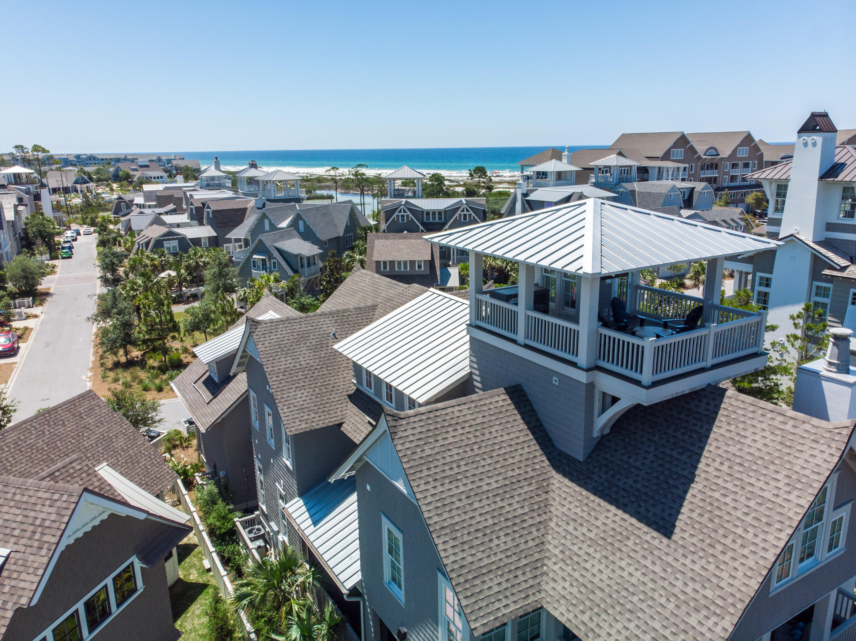 Truly epitomizing the WaterSound Beach lifestyle is a beautiful coastal retreat with professionally designed interiors & breathtaking Gulf of Mexico views. Taking full advantage of the prime location the home borders both Linear Park & Yacht Pond. This residence boasts an open floor plan, wide plank reclaimed hardwood floors, elevated wooden beam ceilings & a plethora of windows plus nano wall that allow in the multitude of natural light. The main level offers seamless indoor & outdoor living with the family room opening to a large screened porch providing additional dining space & fireplace surrounded by seating to enjoy endless beach days. A private jacuzzi tub on a secondary porch is the perfect spot to relax after a long day. The heart of the home is the gourmet kitchen which includes