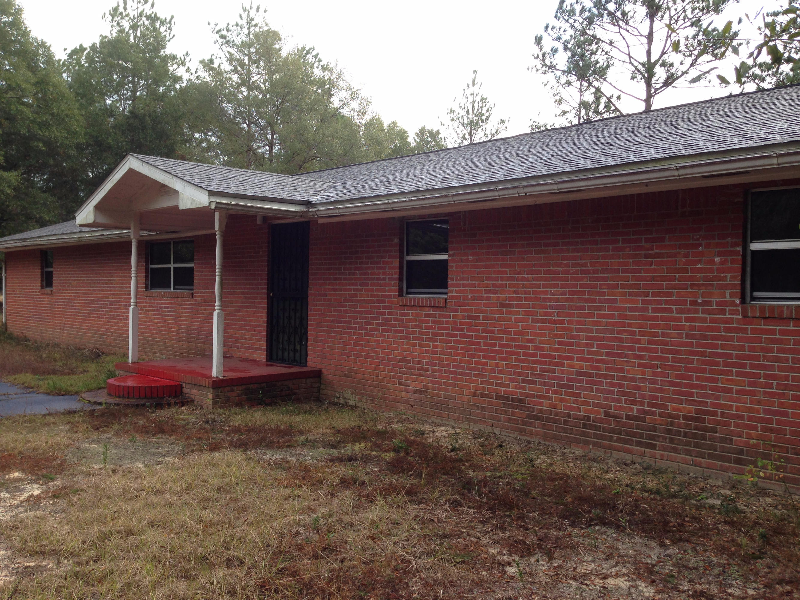 Estate In Probate: Sold ''AS IS'' 3 bed 2 bath 1550 sf brick home built in 1975, sits on 11.18 acre parcel of old growth trees, on corner of Summertime Rd and Hwy 90, just East of Holt. Use separate building as shop, studio, or whatever suits you. Both roofs replaced 3/2013. Fenced garden area protects your crops from rabbits and deer, both seen from time to time on the property. Perimeter is partially fenced. Currently zoned Rural/Residential so HORSES ALLOWED, and chickens too (with some restrictions), but the property might be rezoned for mixed or commercial use since Holt is a growing community. Property across street is zoned Mixed Use. Perfectd candidate for 203K Renovation loan, or cash purchase as it may not pass inspection. Needs new interior walls & most ceilings.