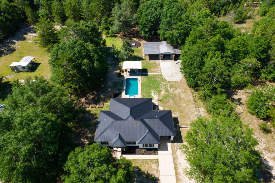 ASSUMABLE VA LOAN AT 5.25%! Escape the hustle and embrace peaceful country living with this beautifully maintained 4-bedroom, 2-bath home on 1.17 acres! Tucked away yet conveniently located near military bases, beaches, and shopping, this property offers the best of both worlds--tranquil rural charm and everyday convenience.Step inside to a spacious, open-concept living area perfect for entertaining. The split floor plan offers privacy, with a generous master suite separated from the guest bedrooms. The updated kitchen is a showstopper, featuring granite countertops, stainless steel appliances (including a double oven), abundant cabinetry, and plenty of prep space for the home chef.Outside, your private backyard oasis awaits. Cool off in the sparkling pool, relax under the covered patio, or gather around the firepit on cooler evenings. A 16x25 workshop with power and RV hookups offers versatile space for hobbies, tools, or toy storage.

The expansive, fenced property is ideal for a small hobby farmbring your goats, mini cows, or chickens! Fruit trees dot the landscape, adding to the natural beauty and functionality of the land.

Recent Updates:

Roof (2021)

HVAC (2022)

Pool liner (2022)

Septic lines (2021)

Water heater (2015)

Whether you're looking for a peaceful homestead or a place to spread out and enjoy Florida living, this one checks all the boxes. Schedule your private showing today!

