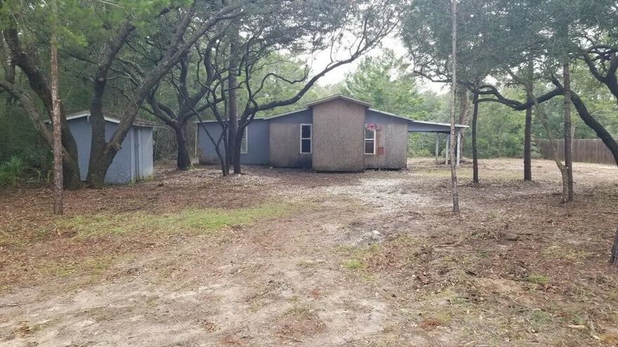 Builders! Investors! This large lot in Navarre has a home built in 1960 that has been taken down to the studs.  Possible septic and well onsite. No tap fees have been paid. No existing electrical power.  Extensive repairs needed, or tear-down.  Lots of potential.